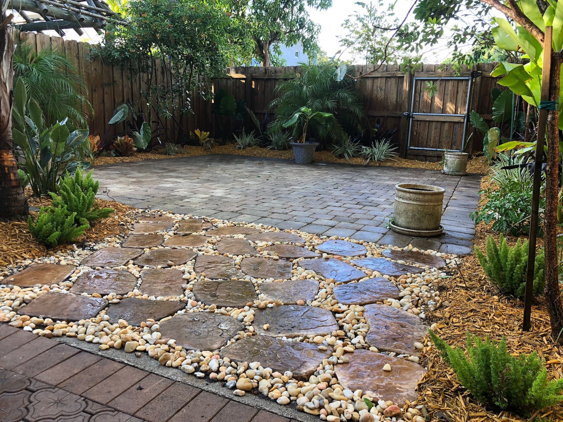 A stone patio with a wooden fence in the background.