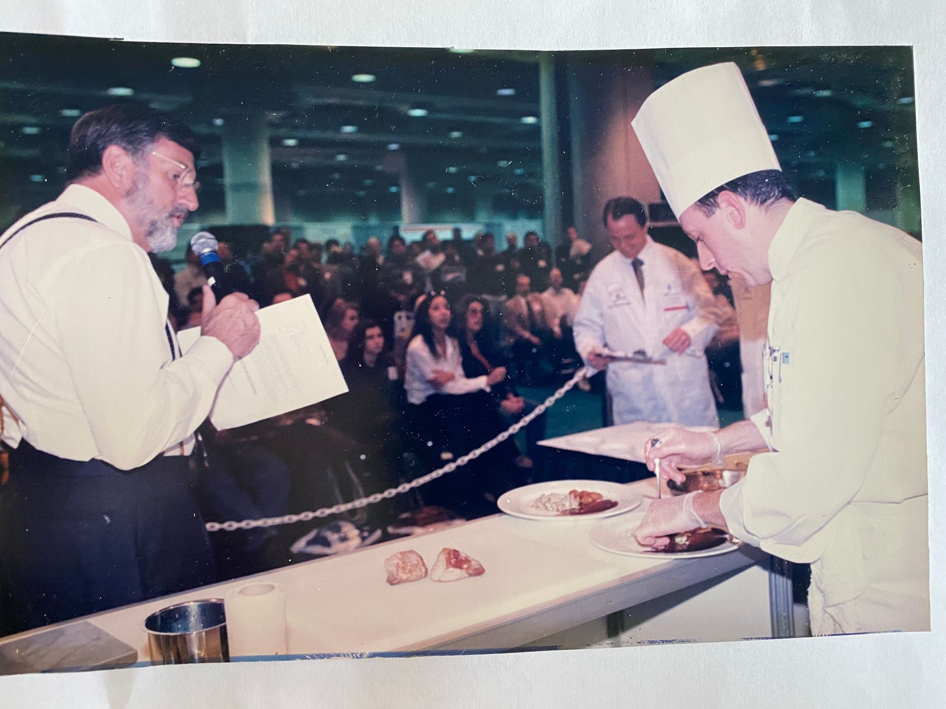 A man in a chef 's hat is speaking into a microphone