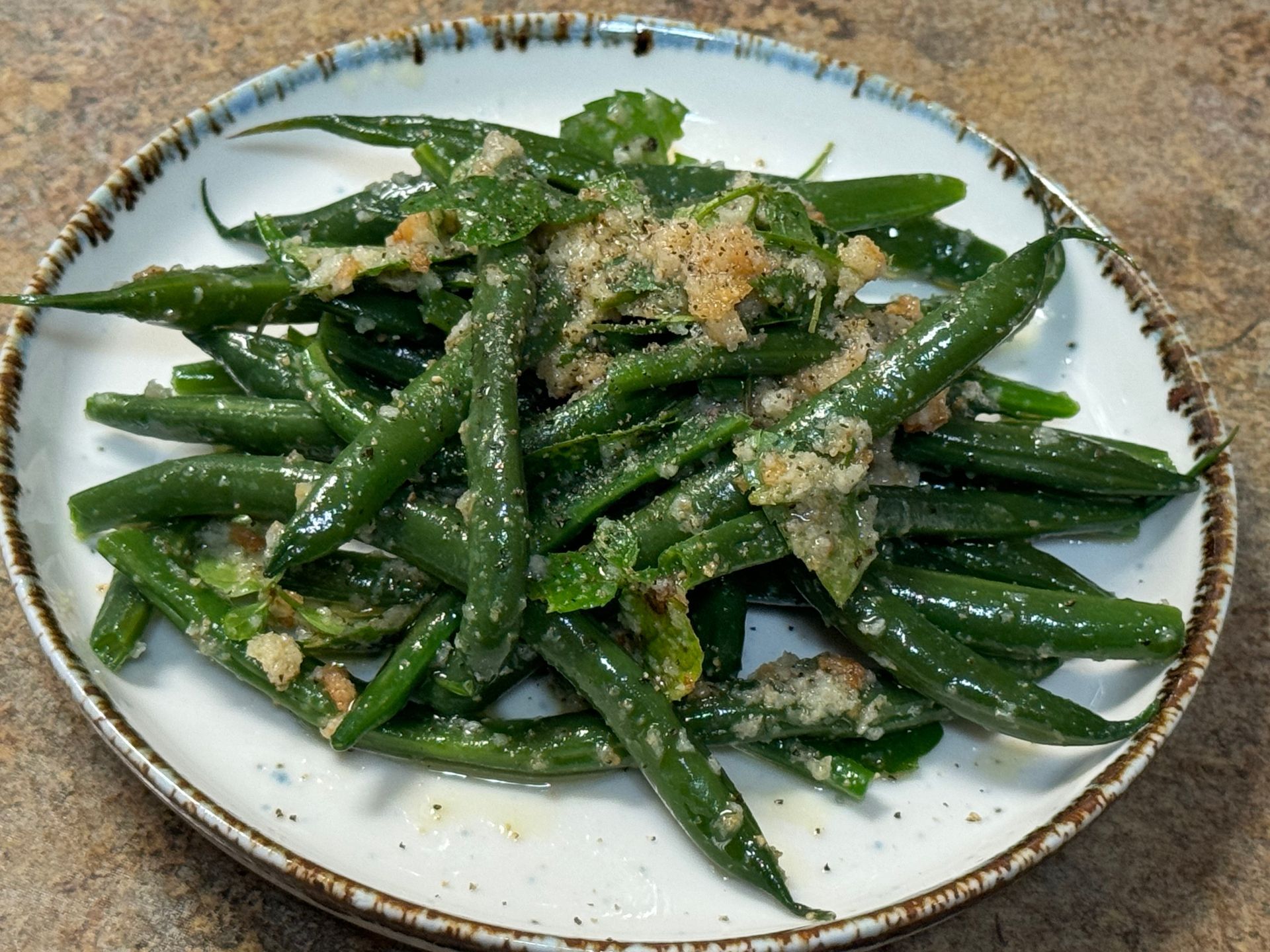 A white plate topped with green beans and garlic