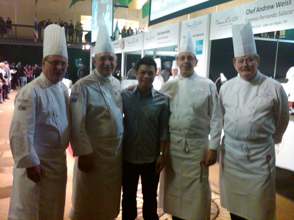 A group of chefs are posing for a picture with a man