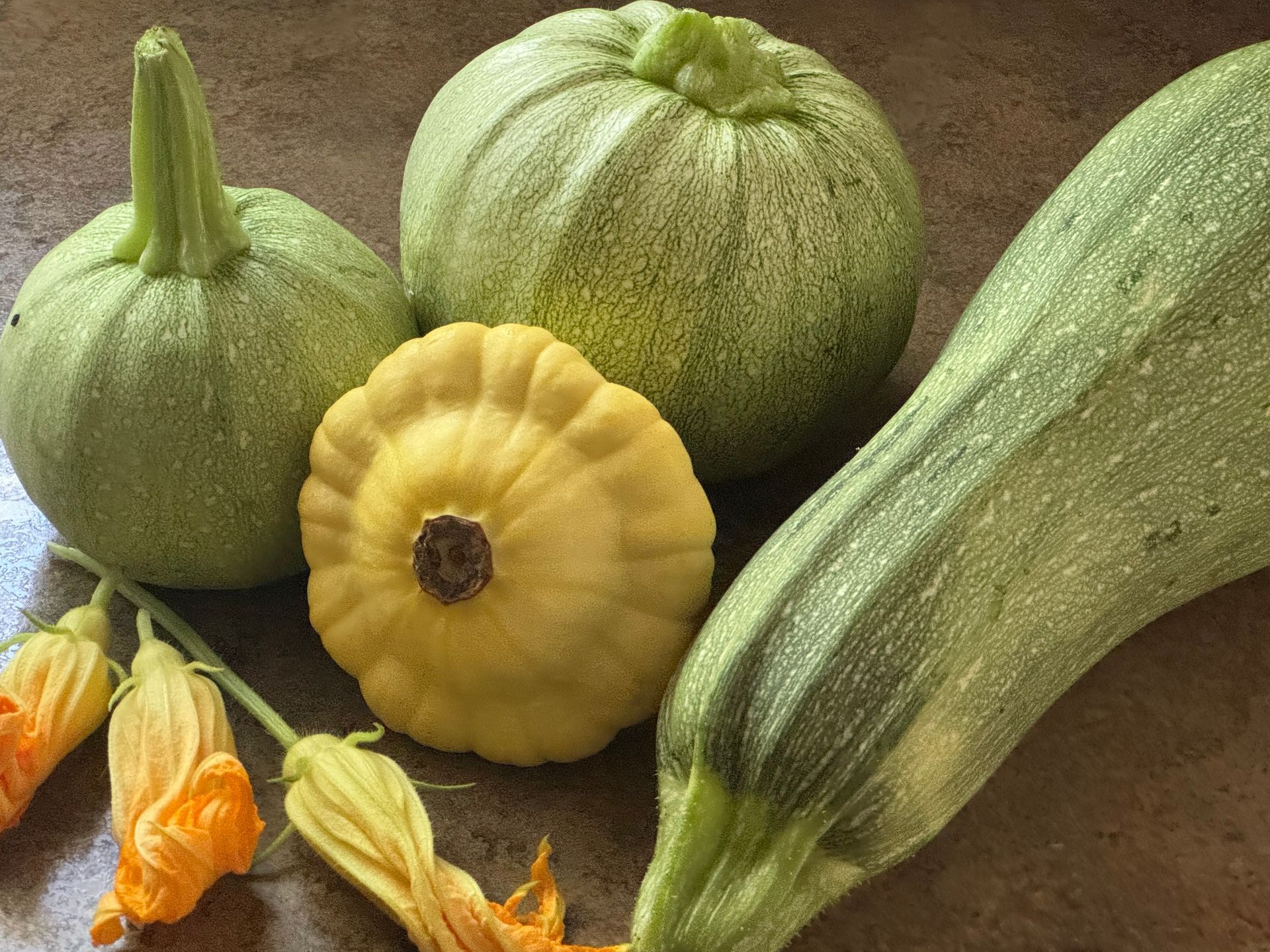 A bunch of different types of squash are sitting on a table.