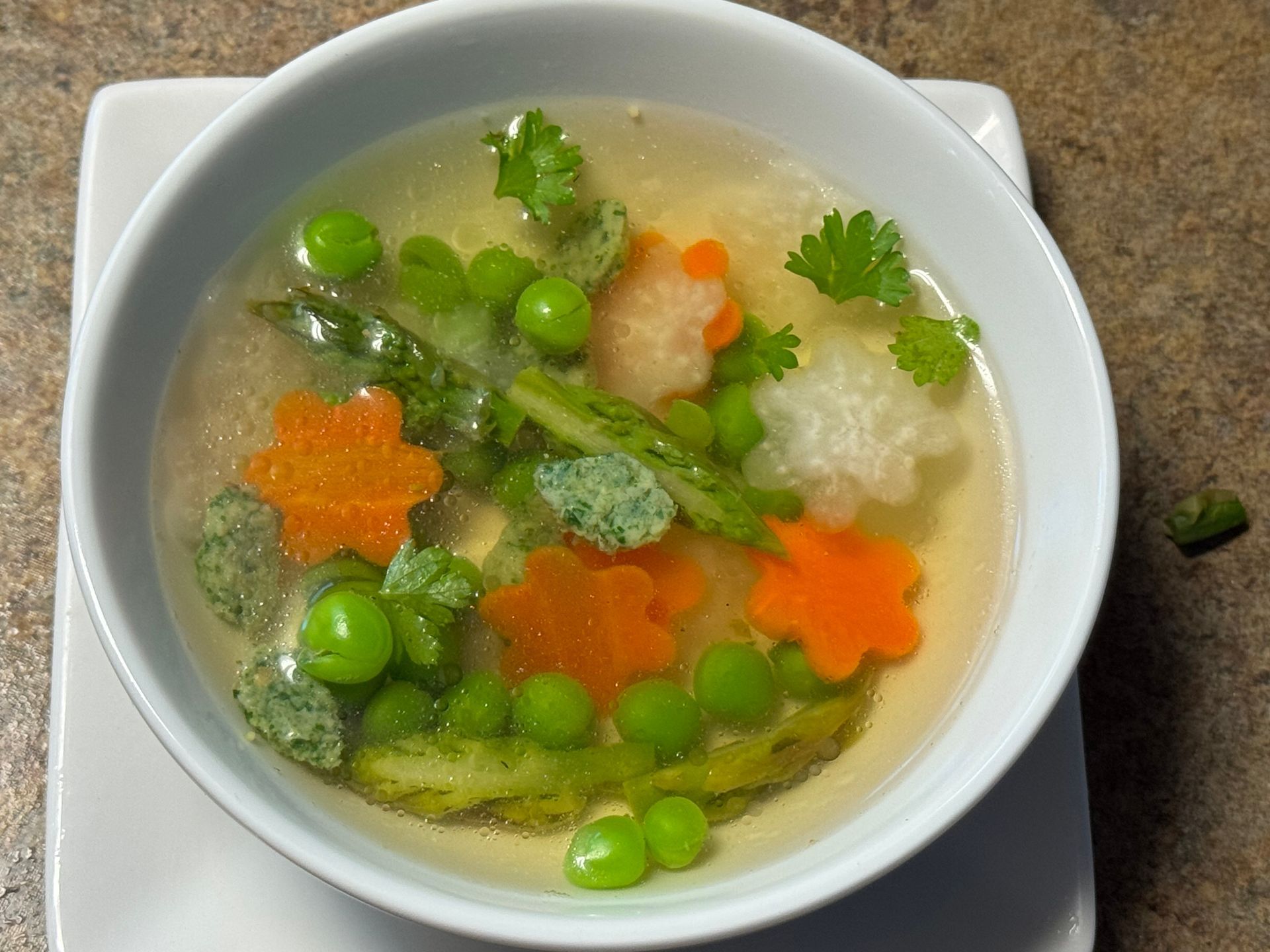 A close up of a bowl of soup with shrimp and potatoes.