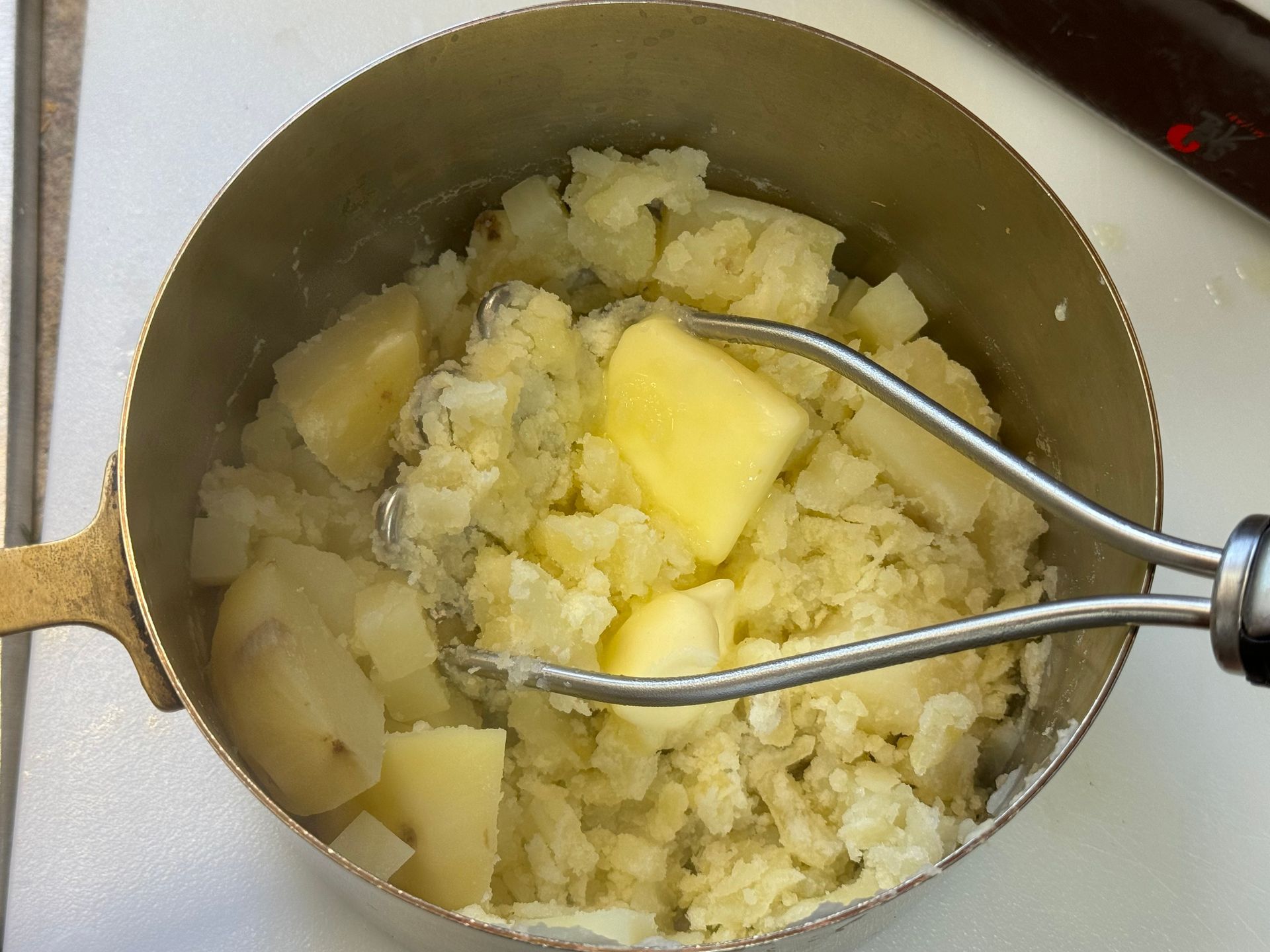 A pot of mashed potatoes with butter in it