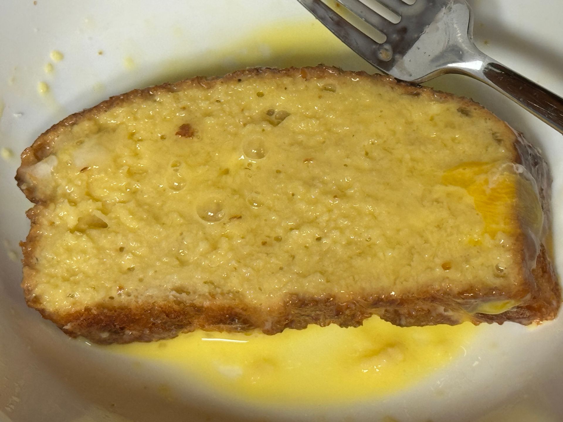 A close up of a slice of bread with a fork in it
