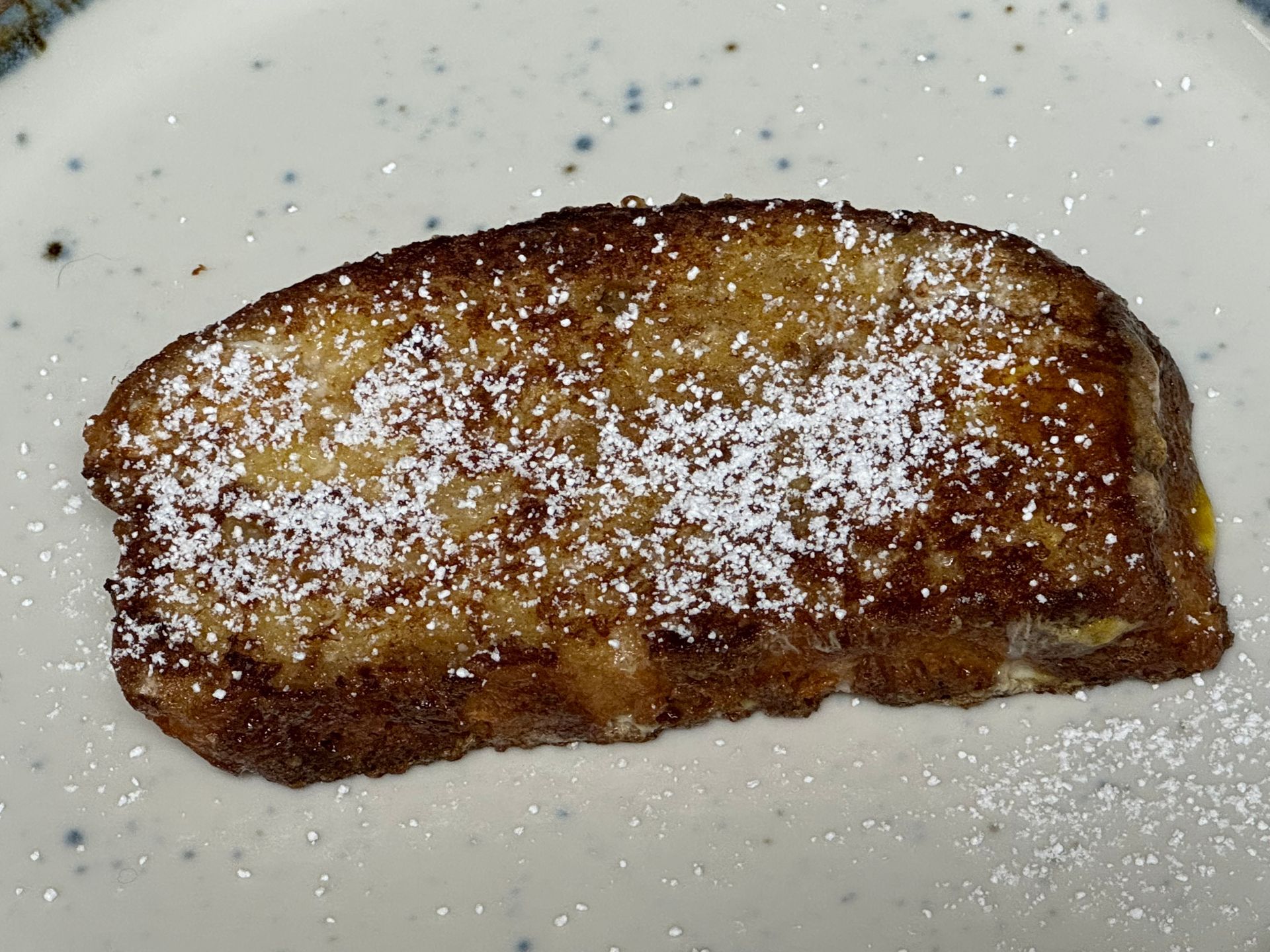 A piece of french toast with powdered sugar on top