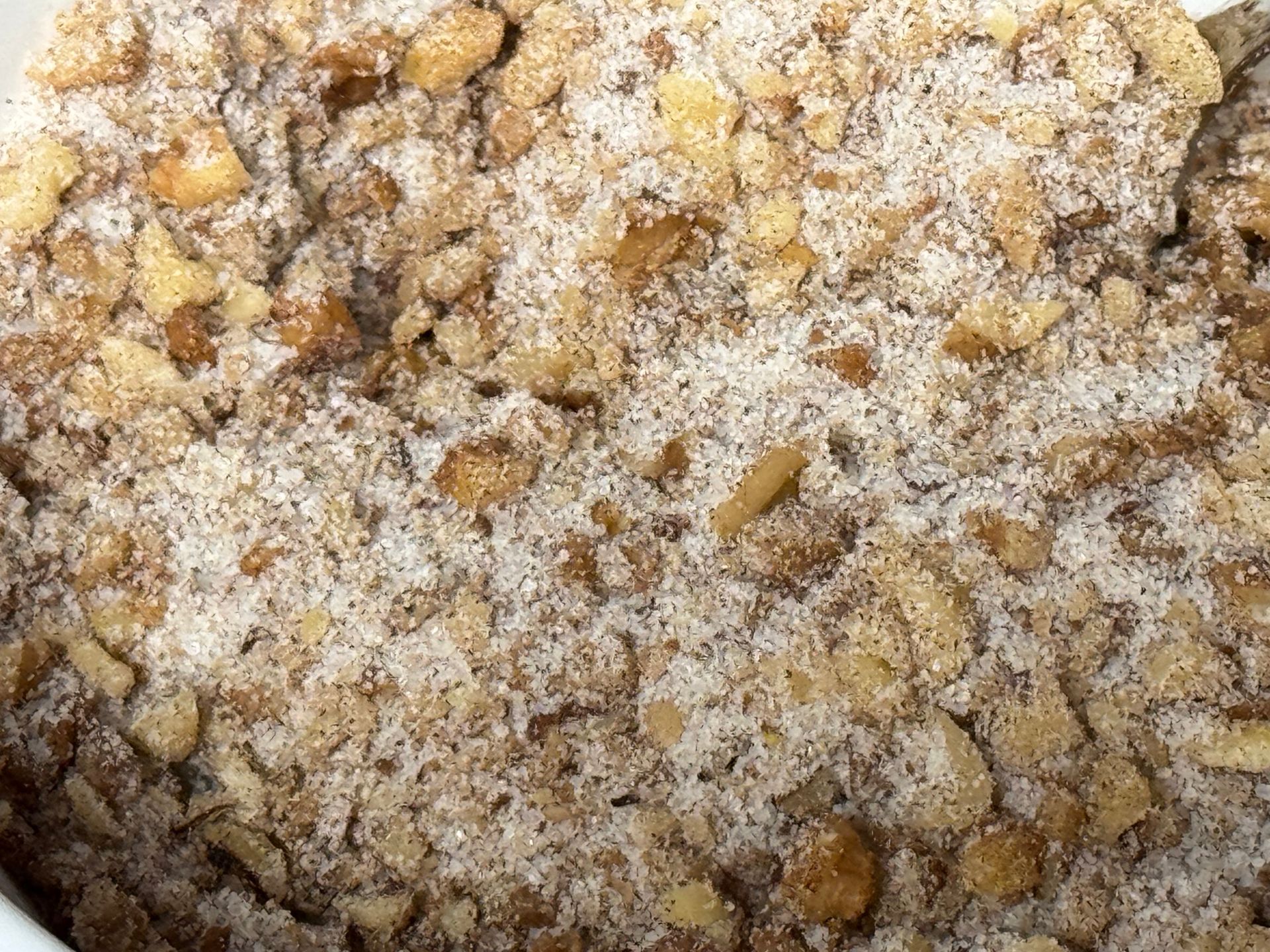 A close up of a bowl of food with nuts and coconut.
