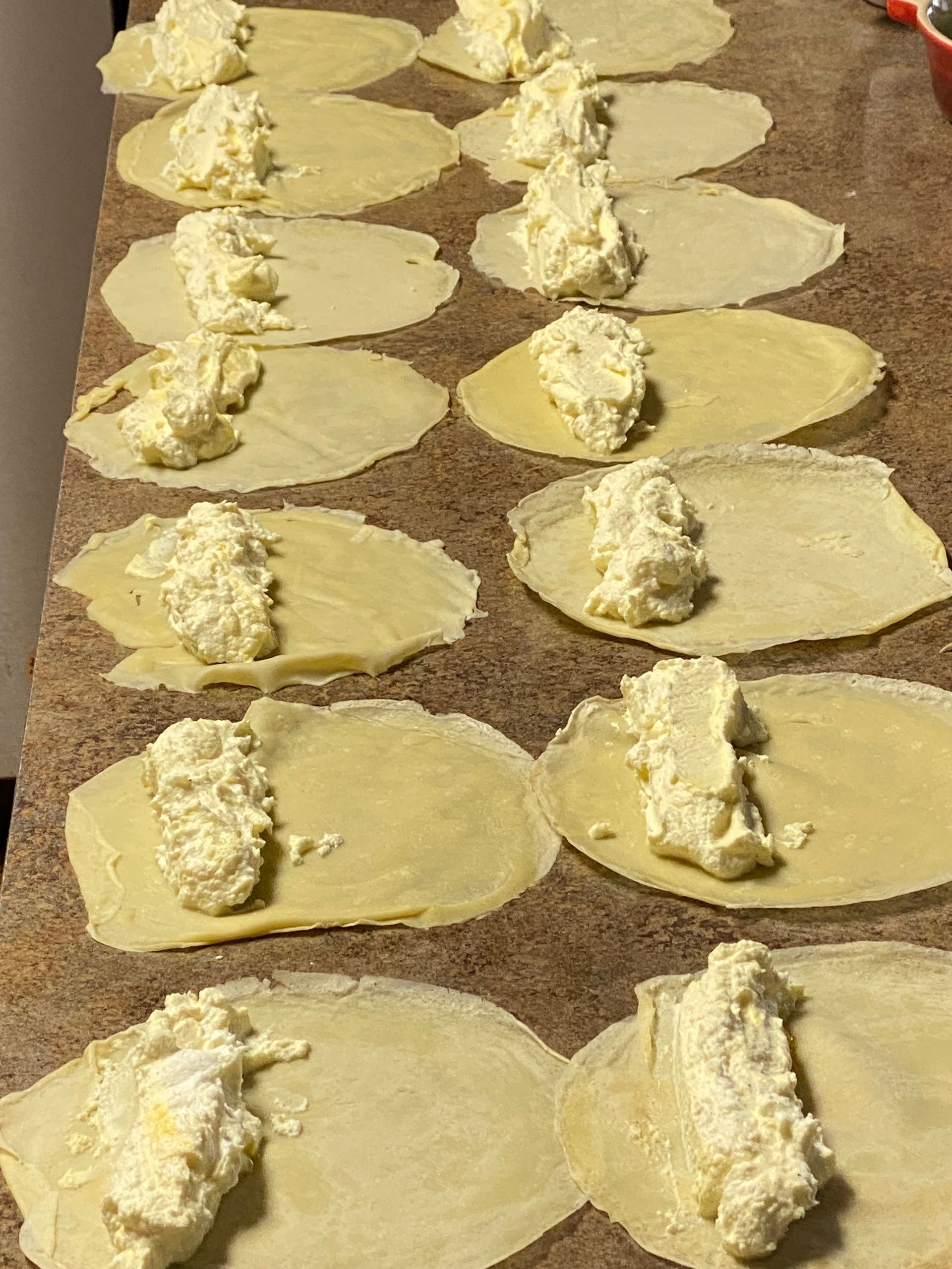 A bunch of rolls with cheese on them are sitting on a table.