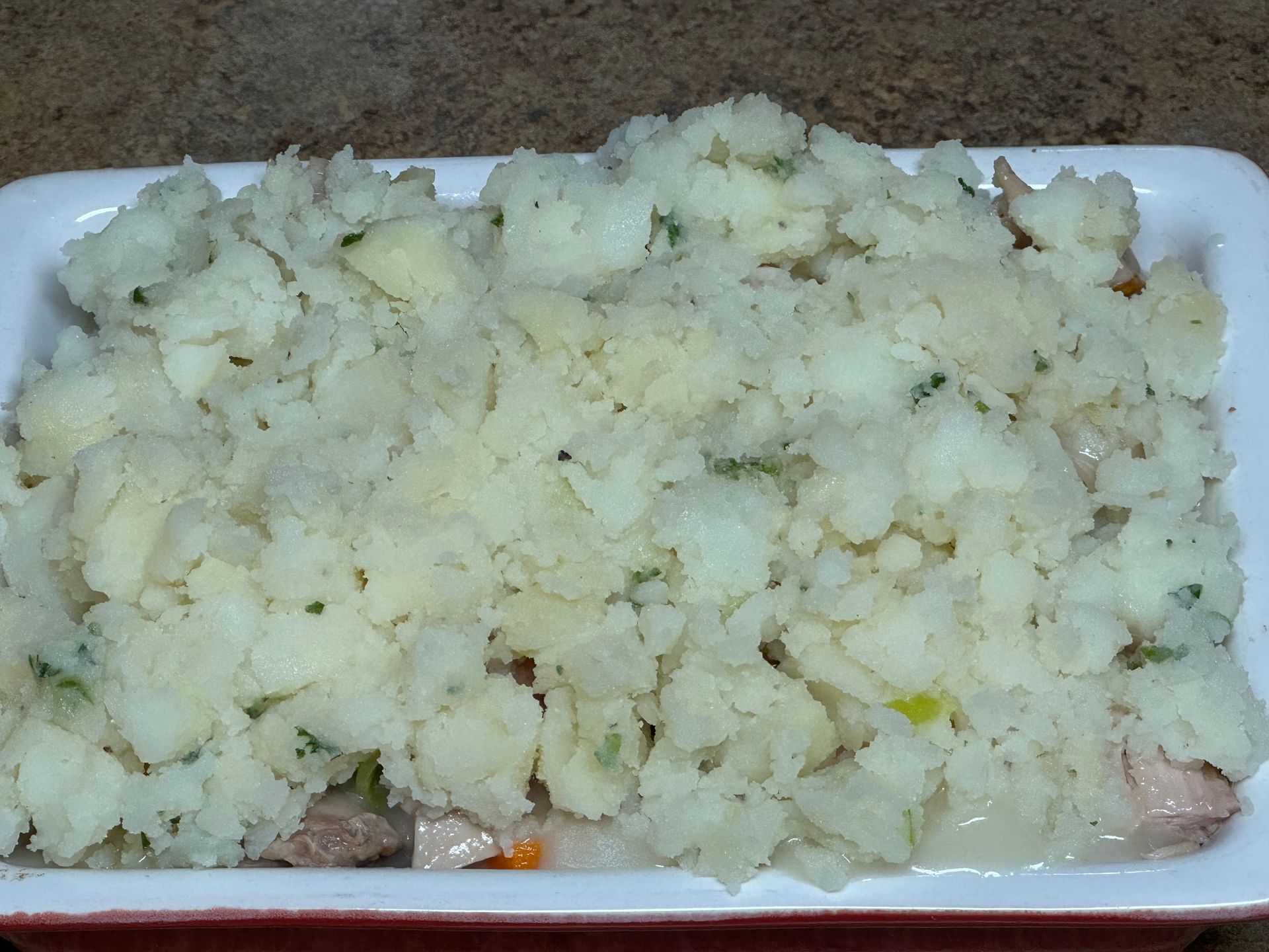 A casserole dish filled with mashed potatoes and meat