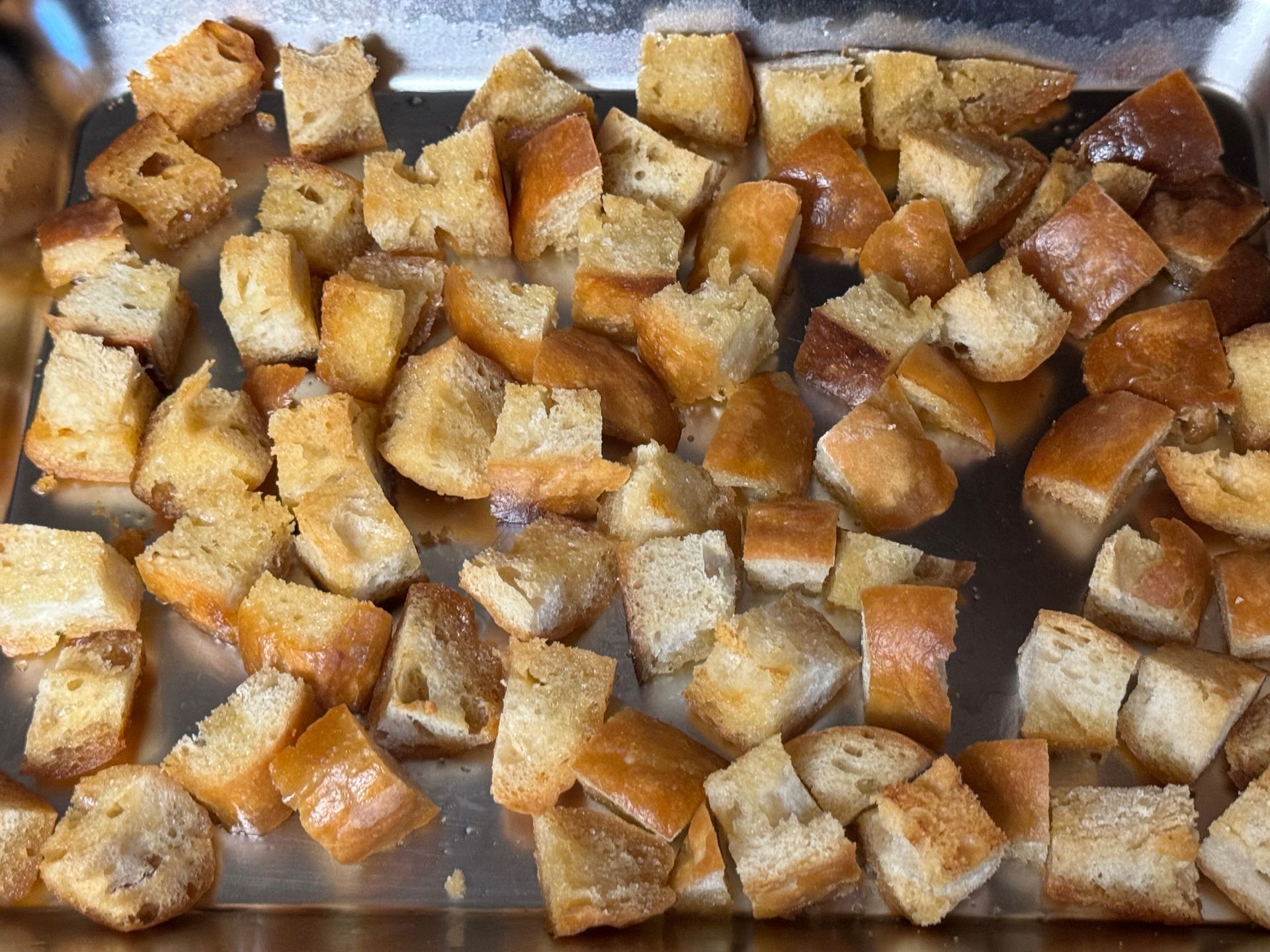 A tray of bread cubes is sitting on a table.