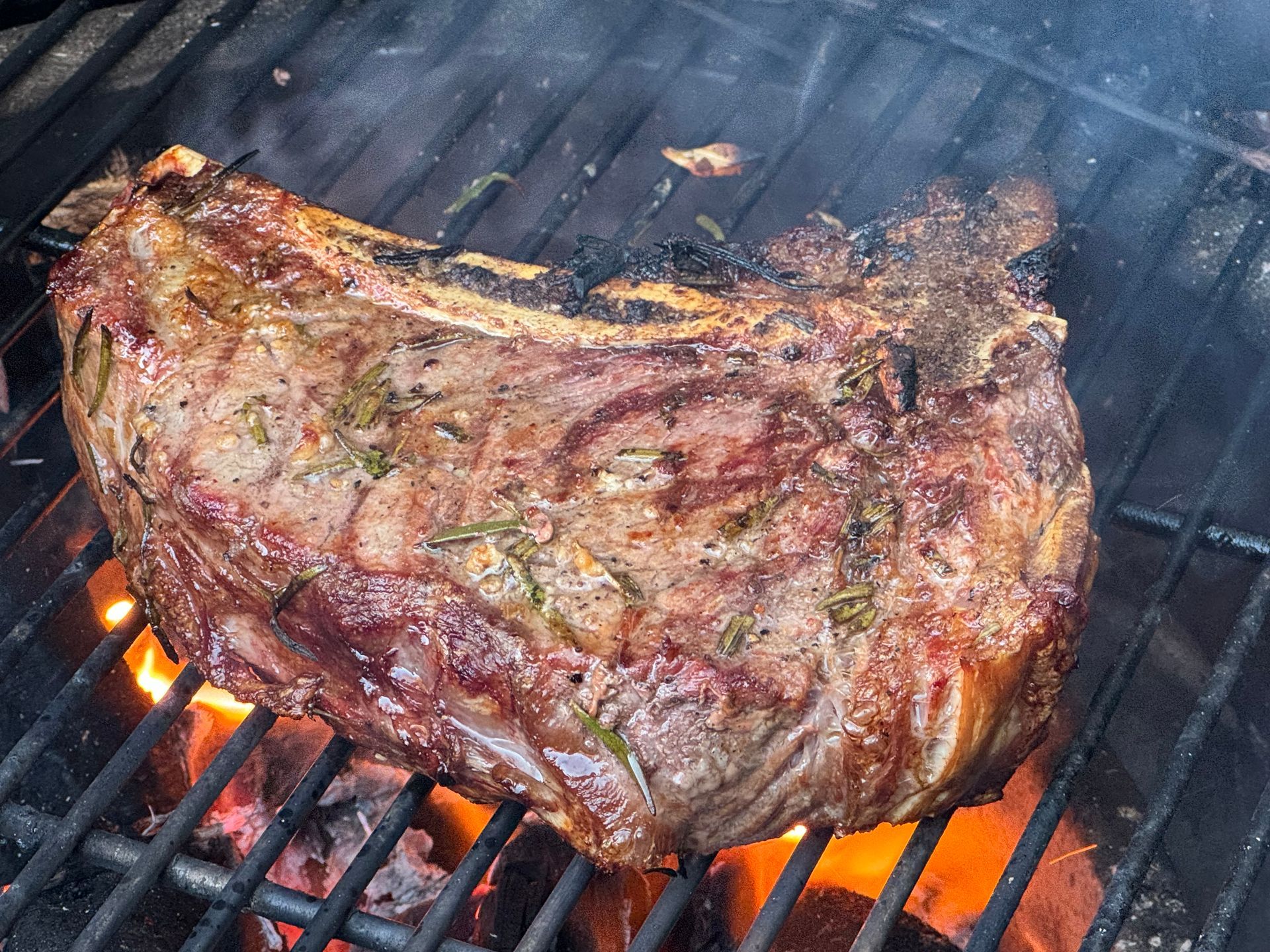 A large piece of meat is cooking on a grill
