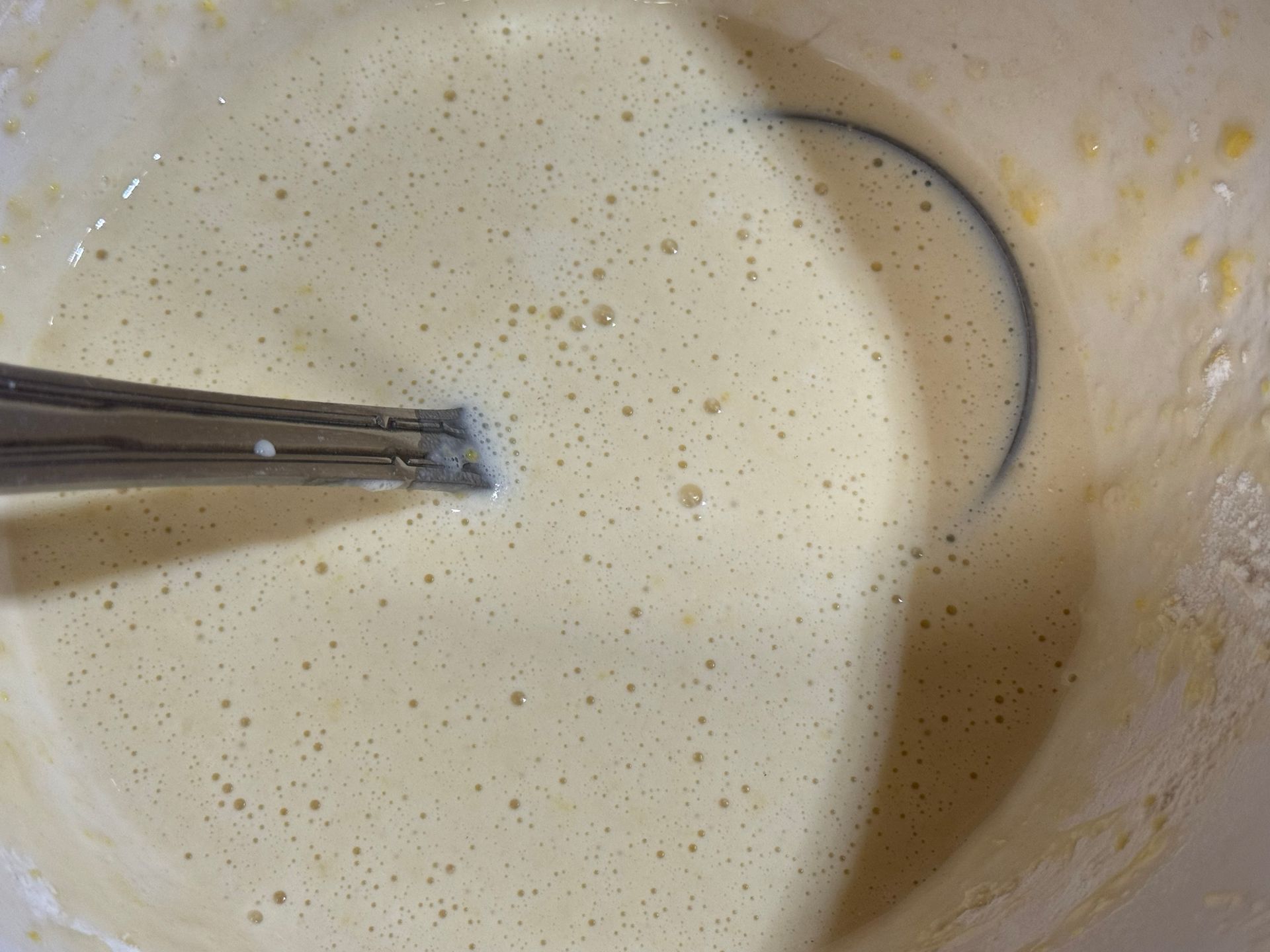 A close up of a bowl of batter with a spoon in it.