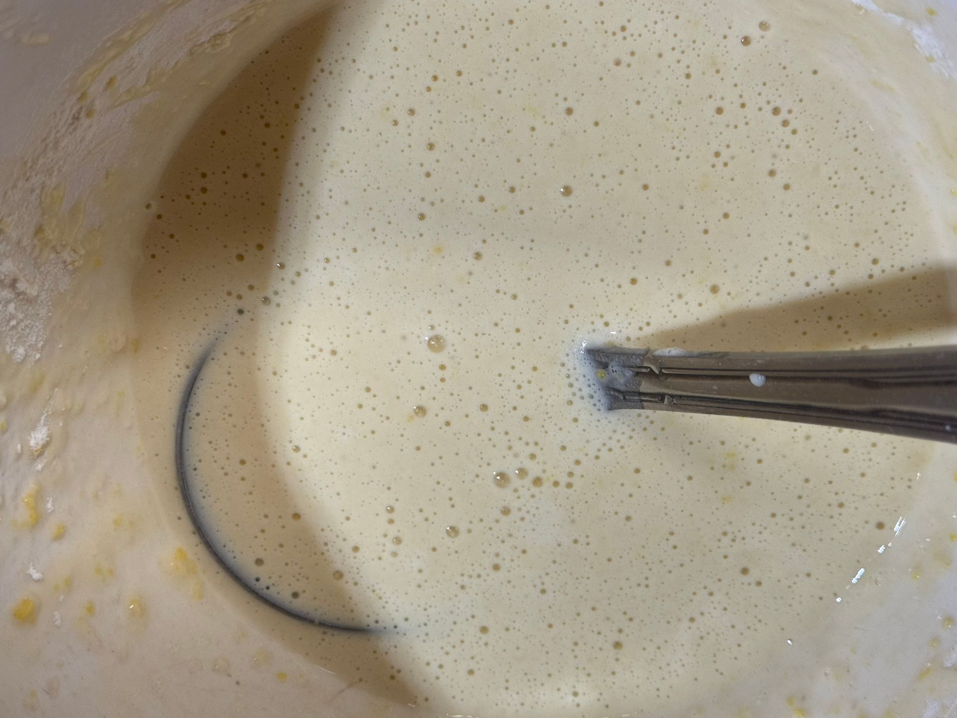 A close up of a bowl of batter with a spoon in it.