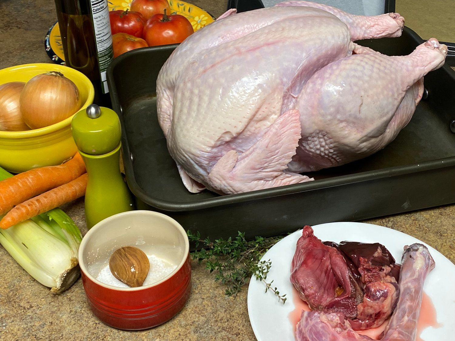 A turkey sitting on top of a pan next to vegetables