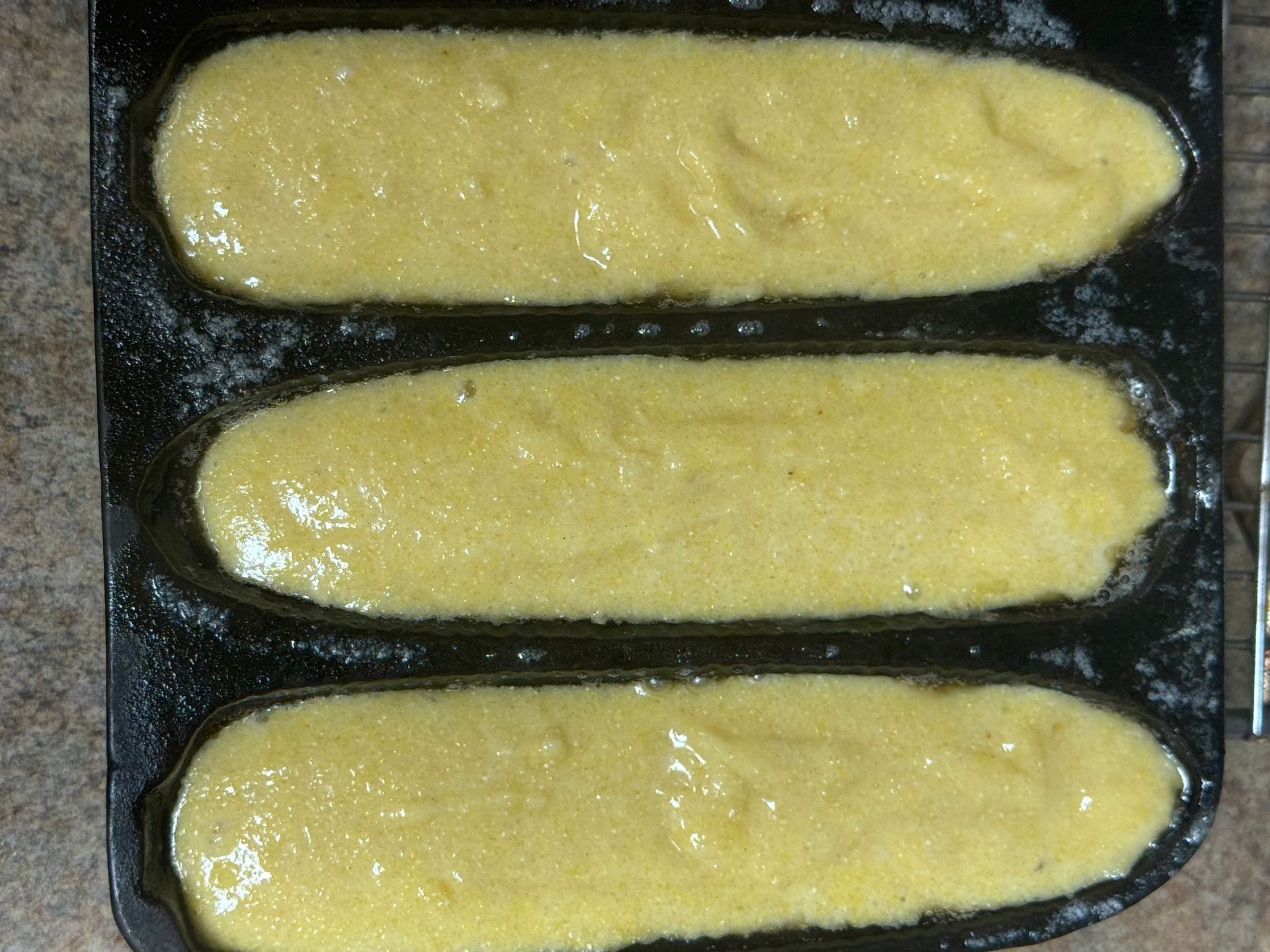 Three loaves of bread are sitting on a tray ready to be baked