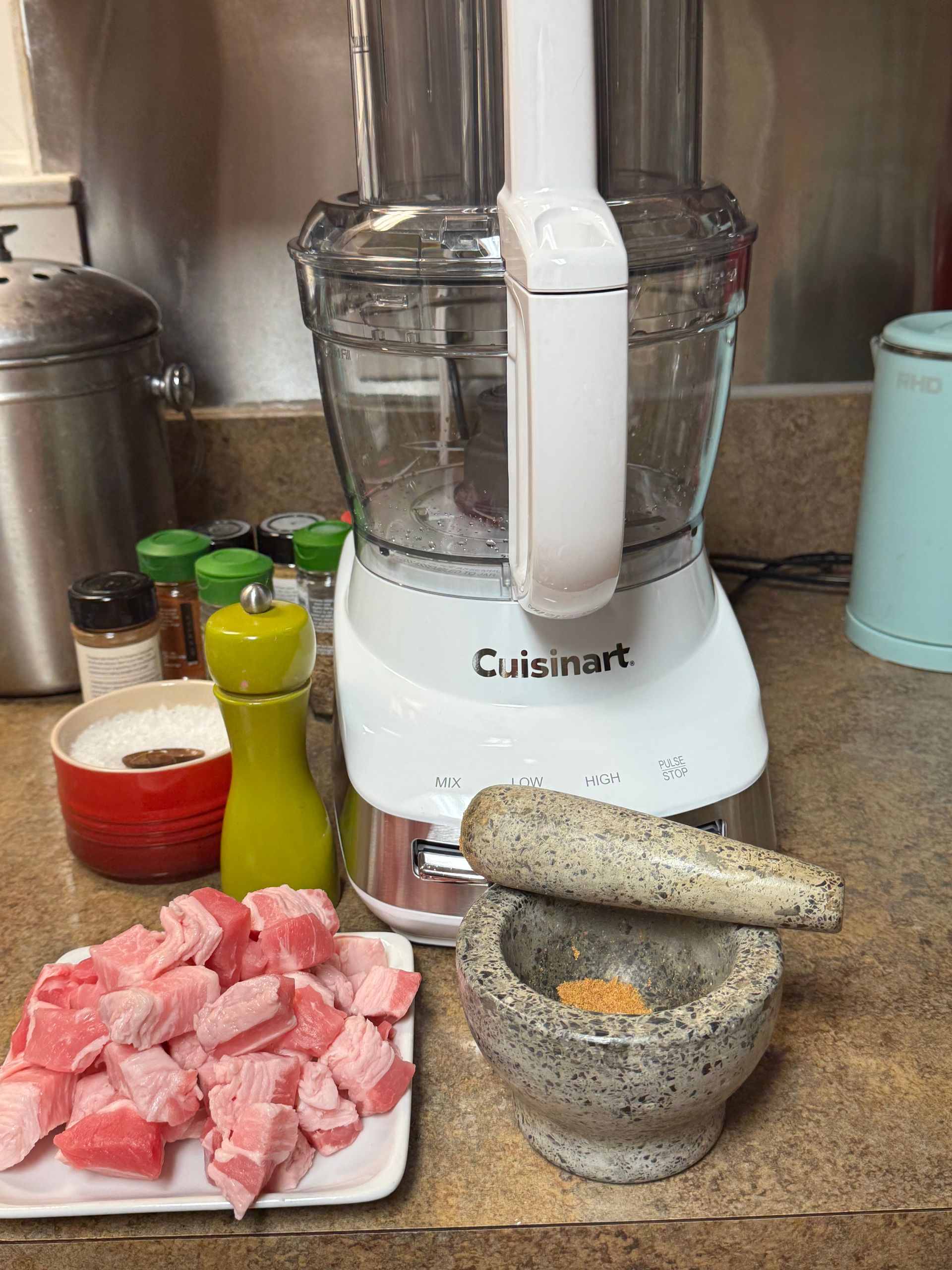 A bowl of ground chicken is sitting on a table.