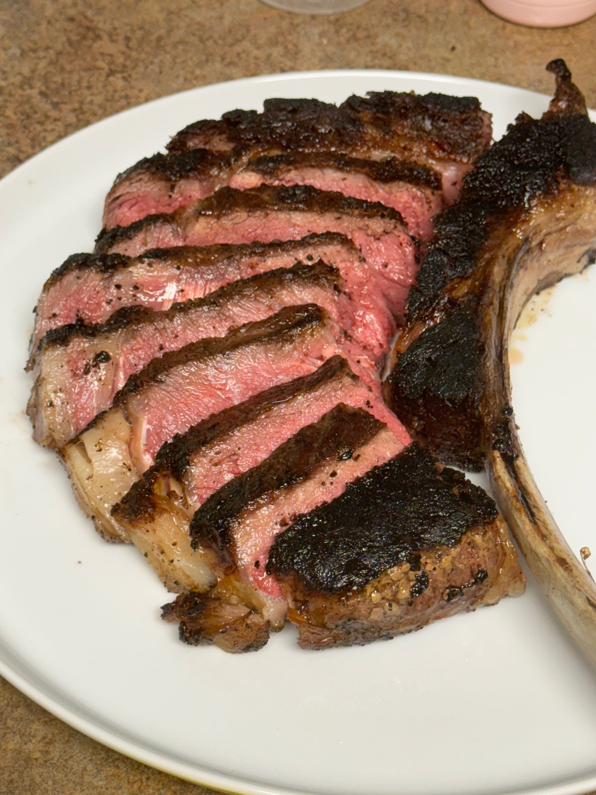 A white plate topped with a large piece of steak