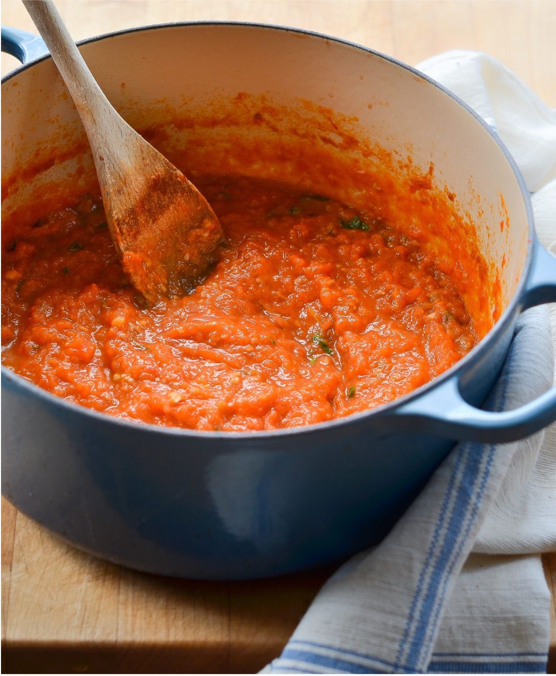 A pot of tomato sauce with a wooden spoon in it