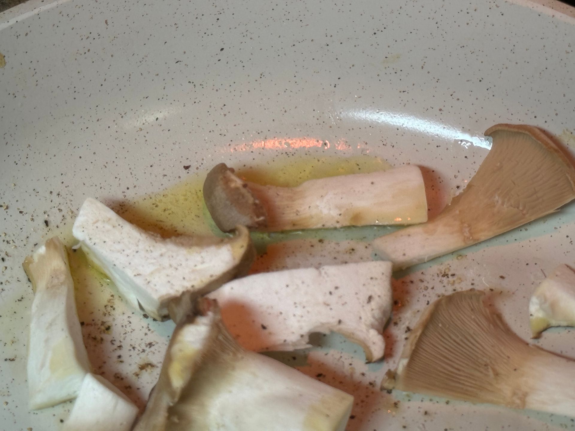 Mushrooms are being cooked in a pan with oil
