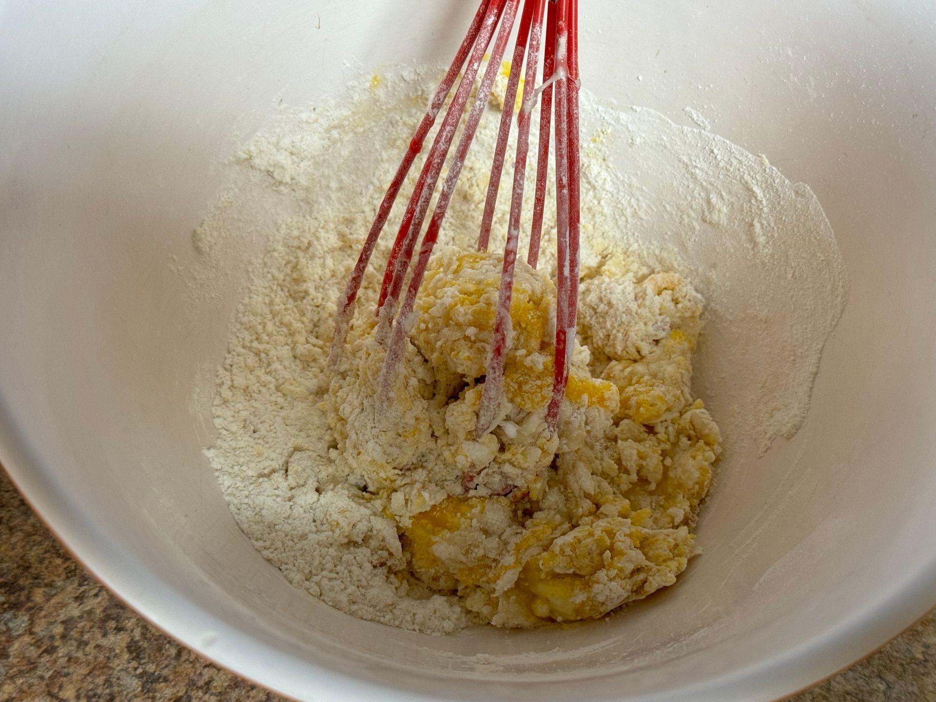 A bowl of food with a whisk in it.