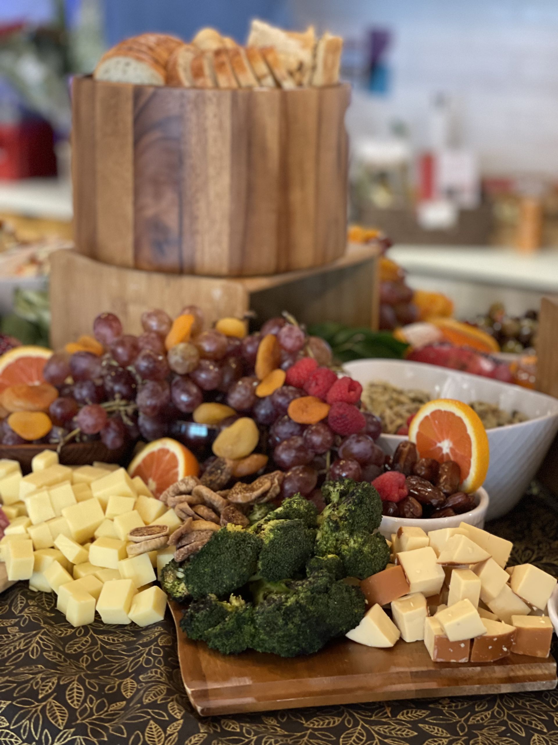 Charcuterie-style fruit and cheese platter with bread in a wooden bowl on a table