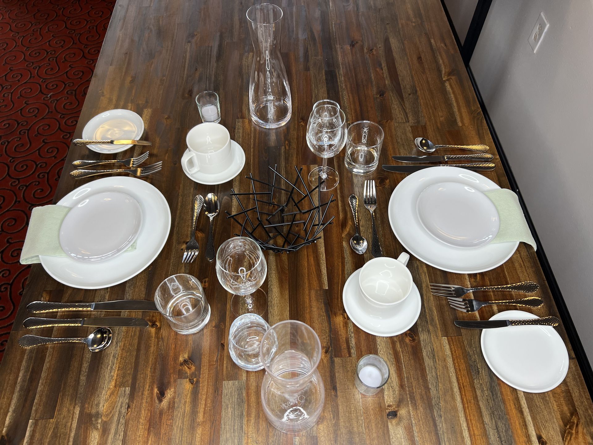 Dining table set with plates, glasses, cutlery, and cups for a meal
