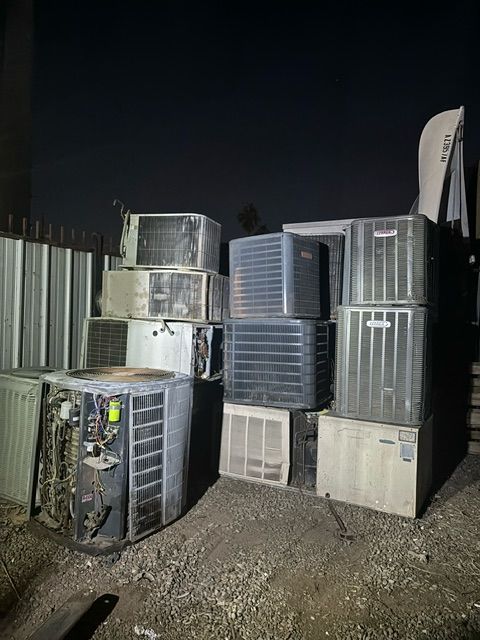 A bunch of air conditioners are stacked on top of each other.