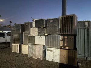 A bunch of old air conditioners are stacked on top of each other.