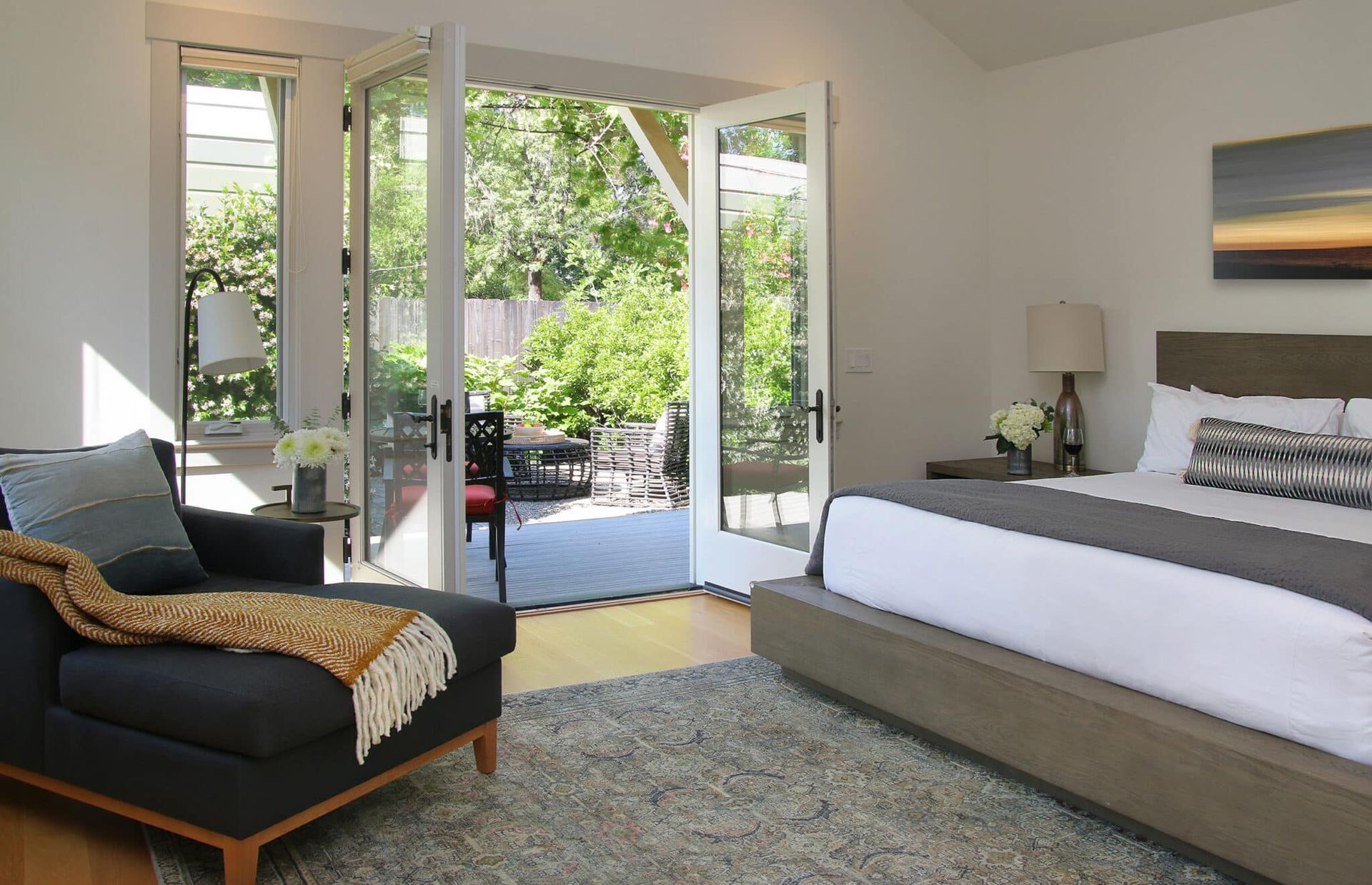 A bedroom with a large bed and a chair