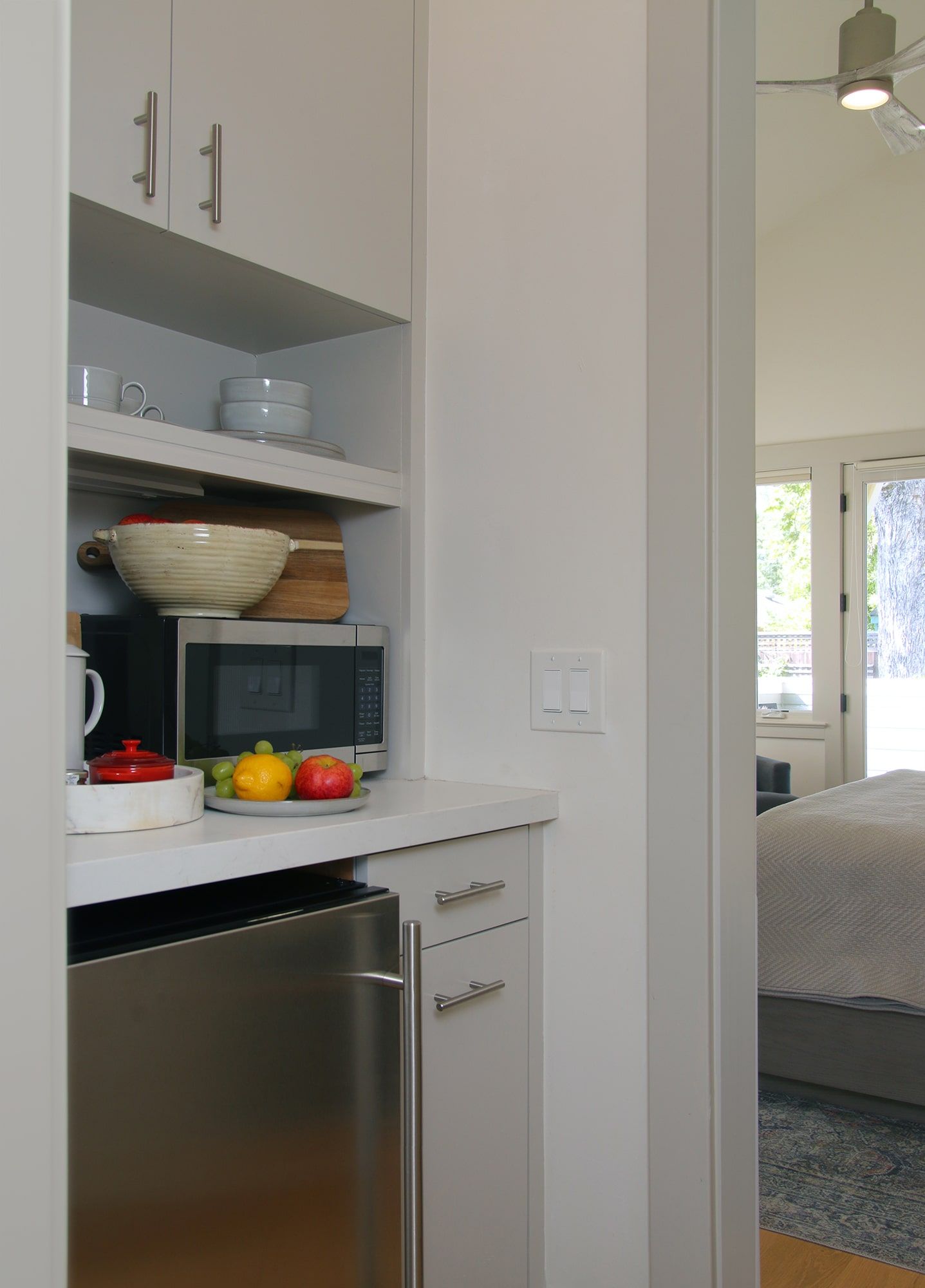 A kitchen with a stainless steel refrigerator and a microwave