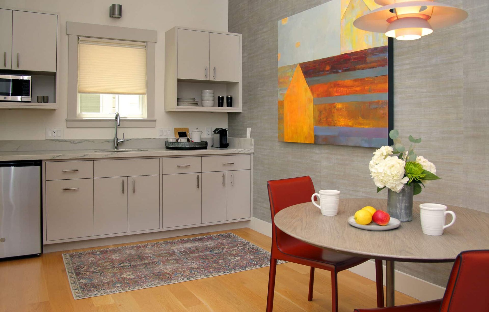 A kitchen with a table and chairs and a painting on the wall