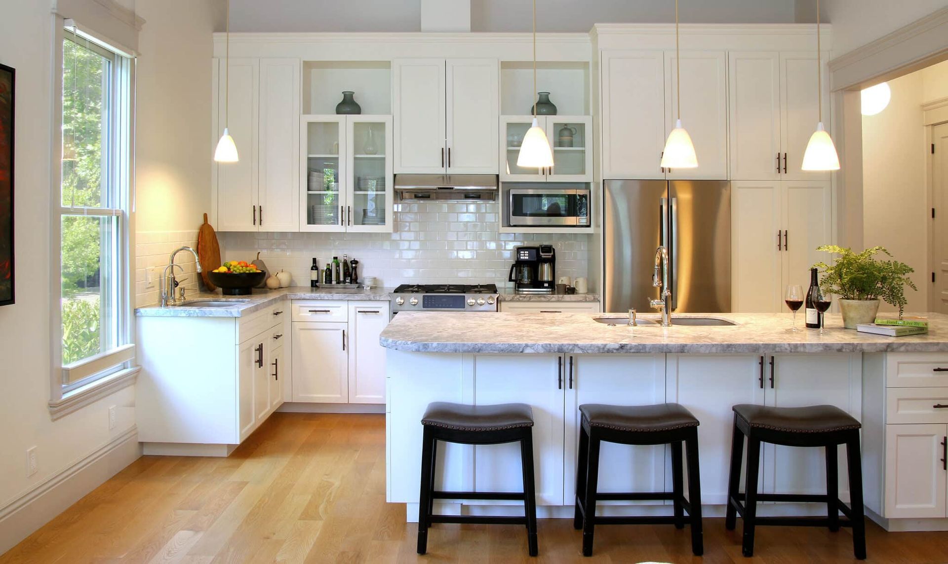A kitchen with white cabinets and stainless steel appliances