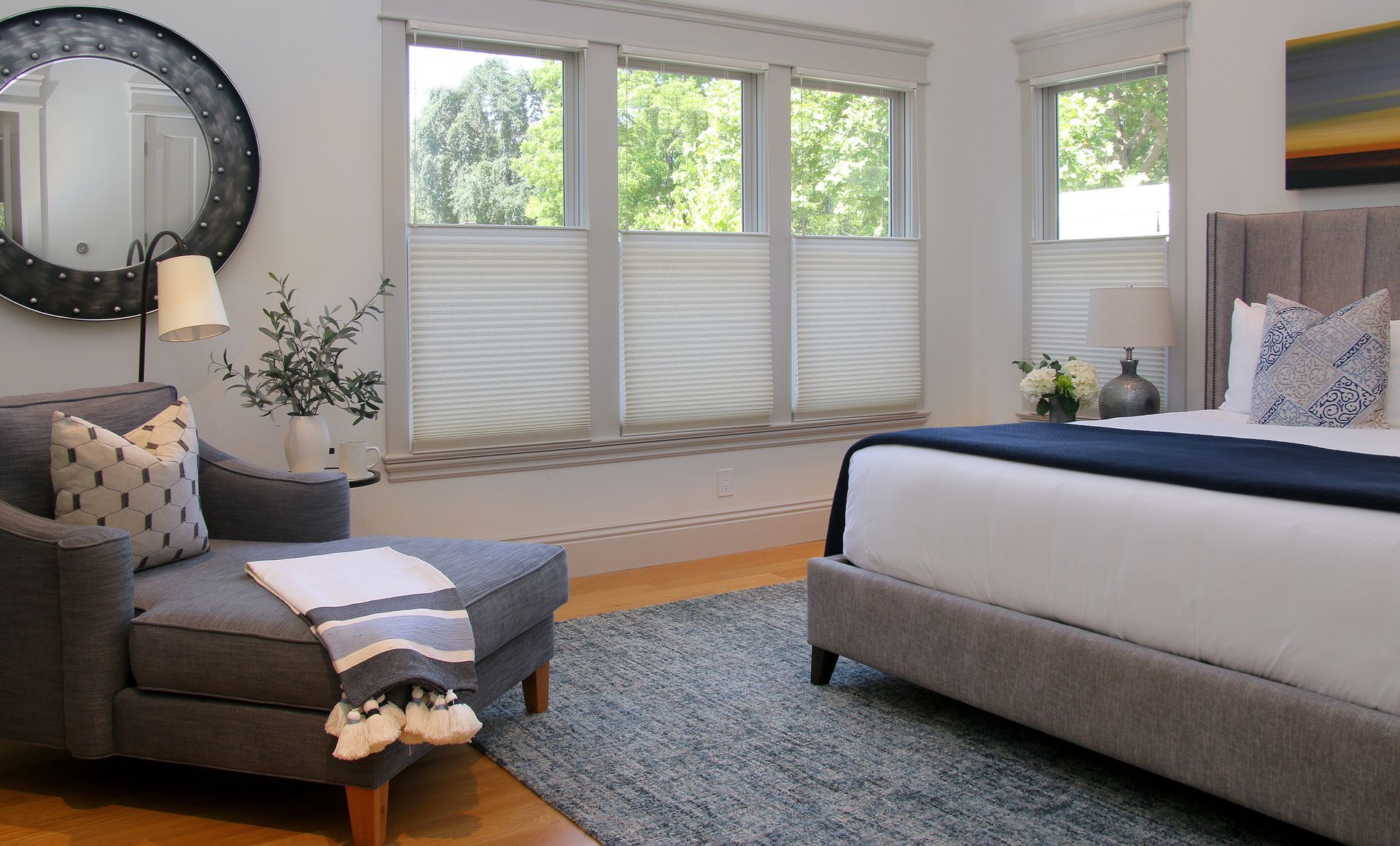 A bedroom with a large bed , chair , and mirror.
