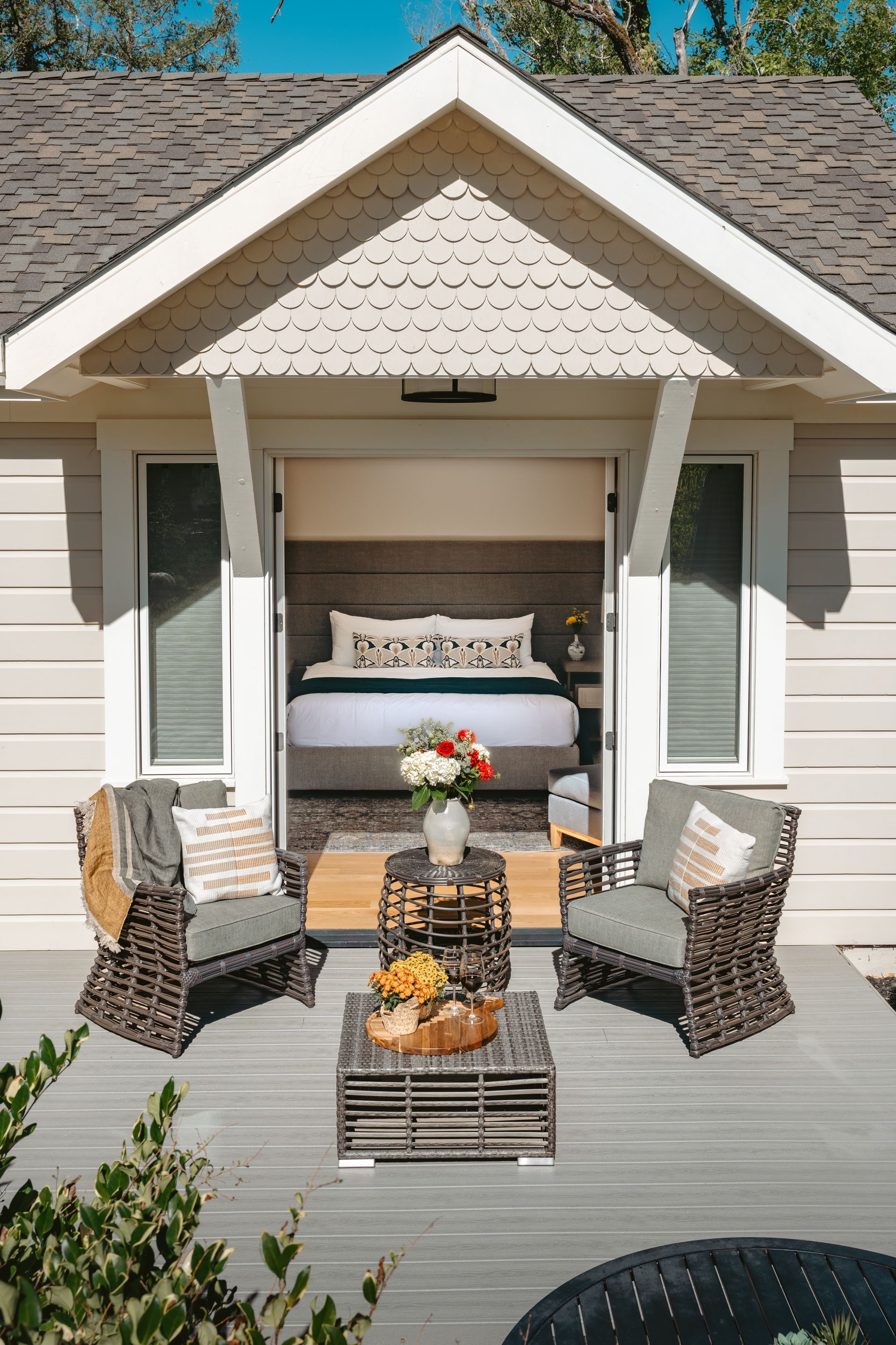 A small white house with a porch and a fence