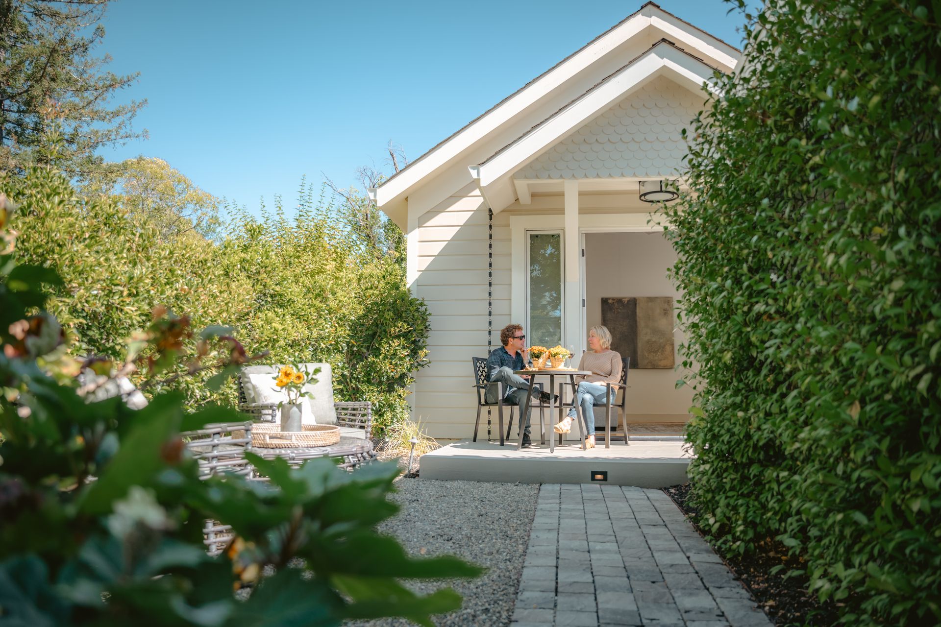 A house with a porch and a wooden fence in front of it.