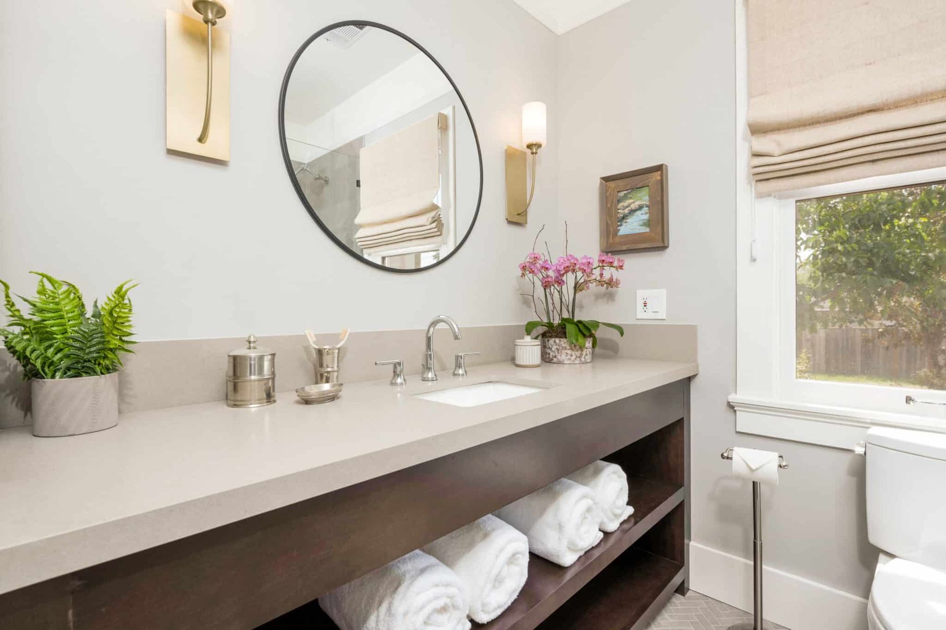 A bathroom with a sink , toilet and mirror.
