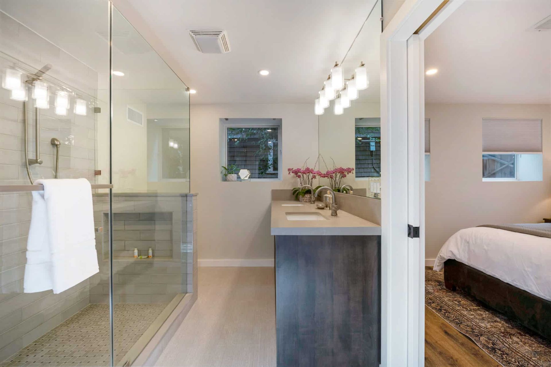 A bathroom with a walk in shower and a sink