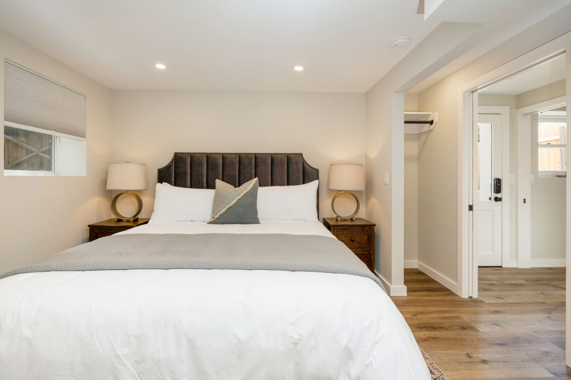 A bedroom with a king size bed and two lamps.