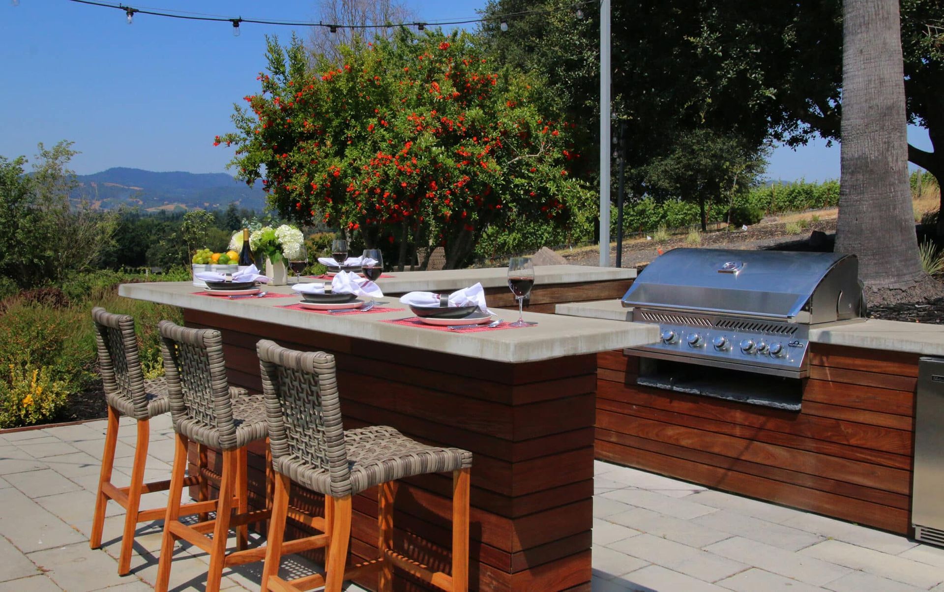 A patio with a table and chairs and a grill.