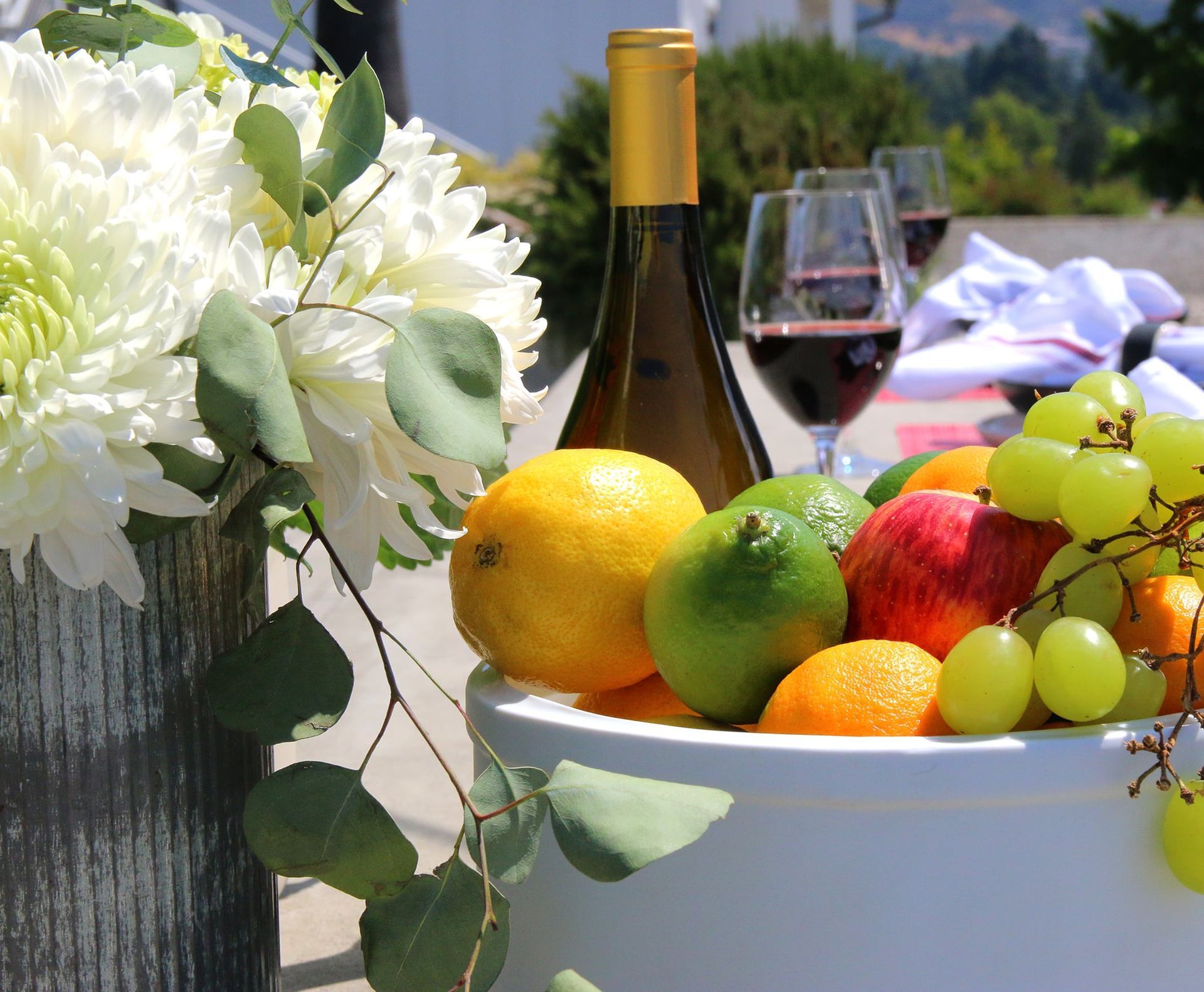 A bowl of fruit and a bottle of wine on a table