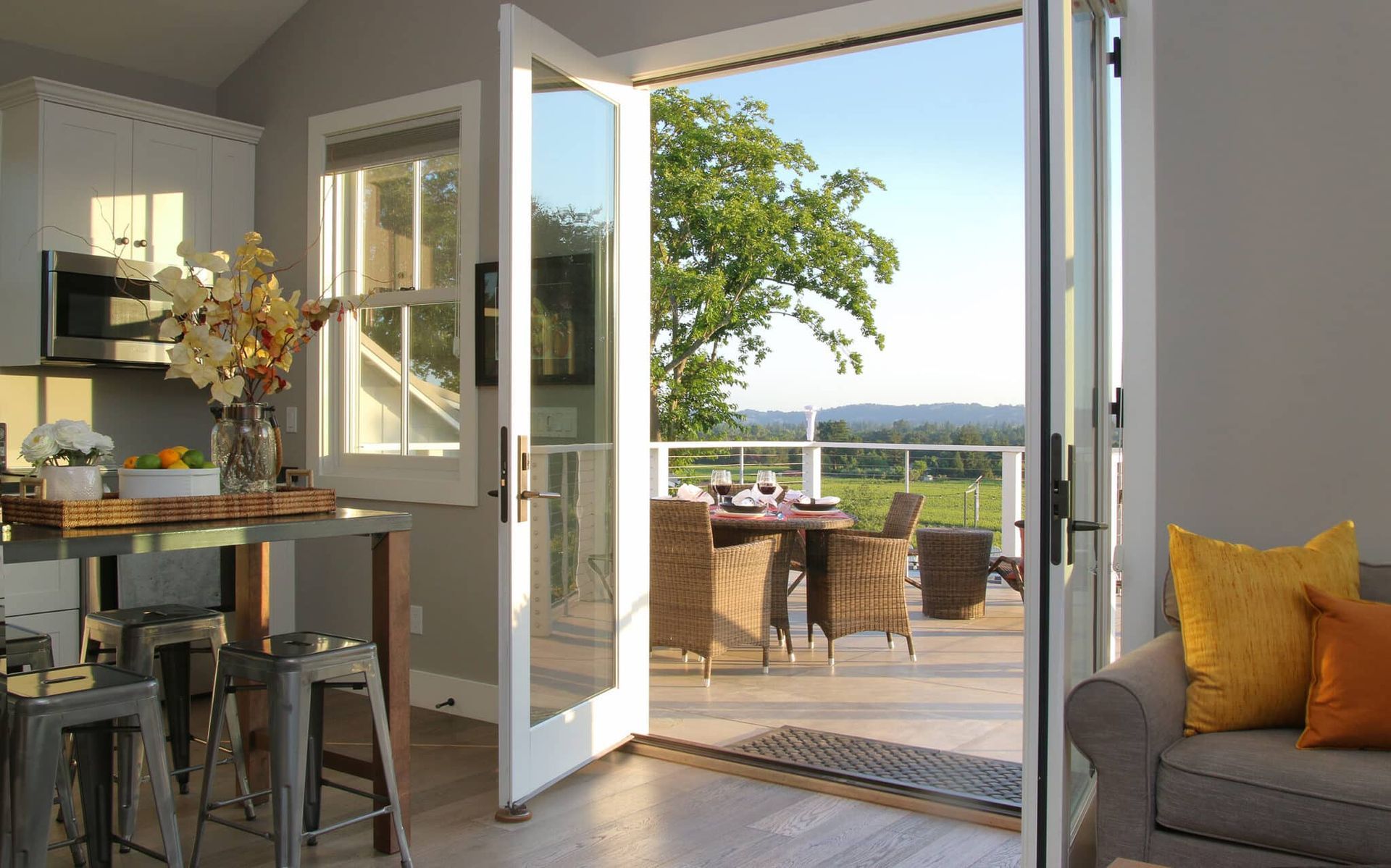 A living room with a view of a balcony and a table and chairs