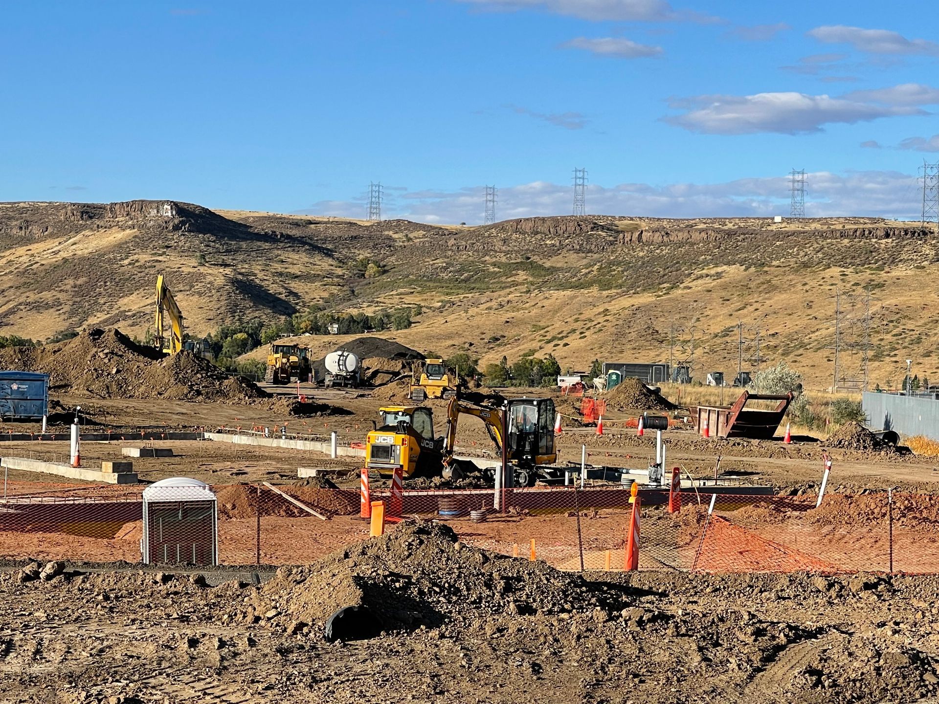 A construction site with a lot of machinery and a lot of dirt.