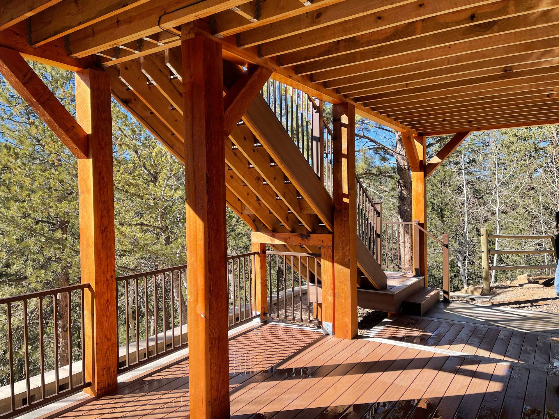 A wooden deck with a metal railing and stairs