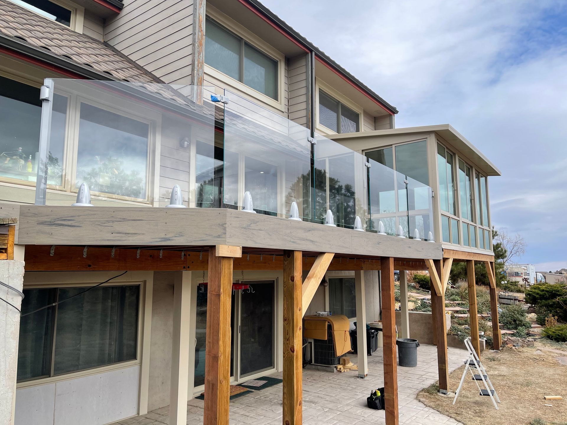 A large house with a large deck and a glass railing.