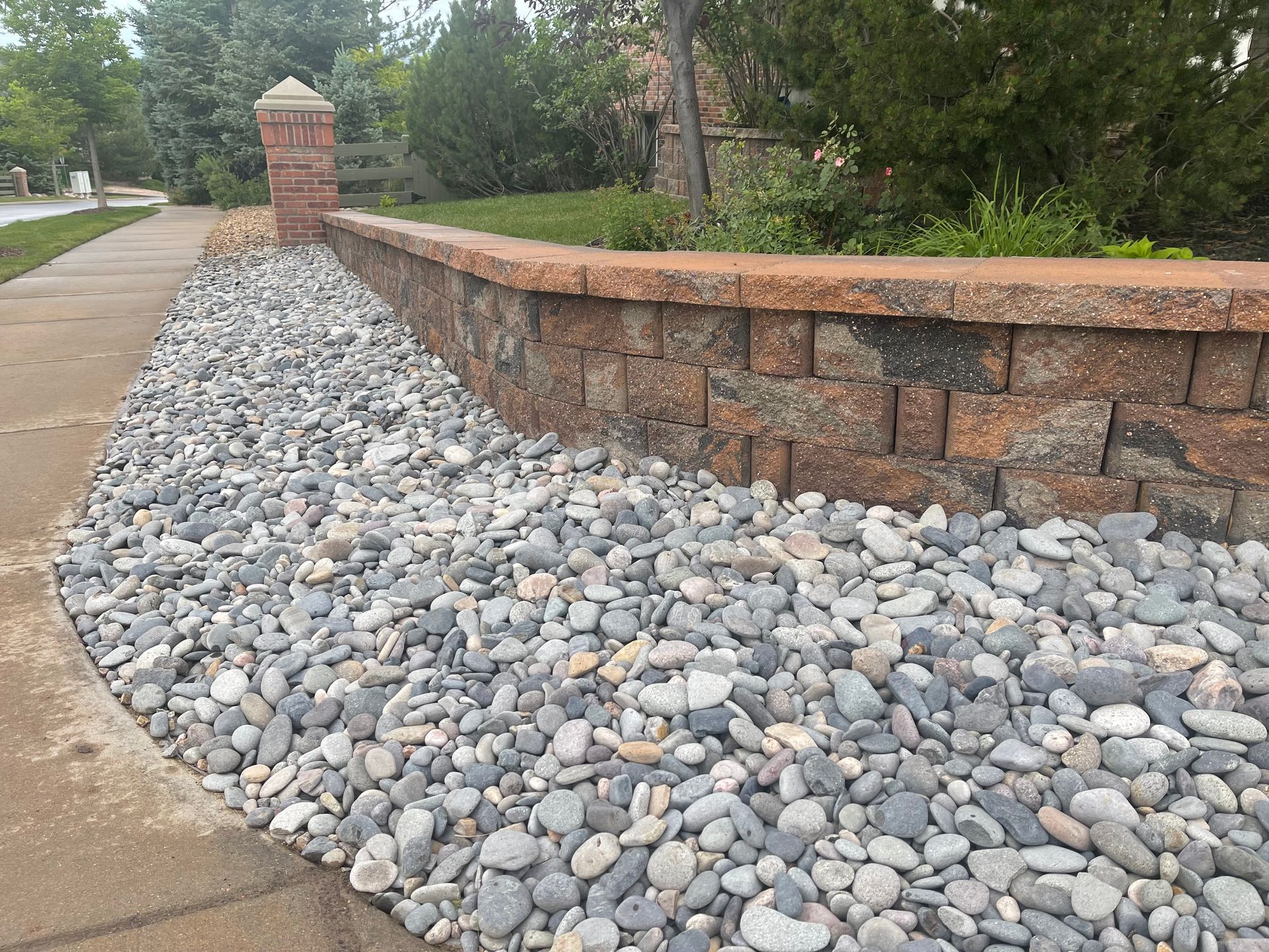 A pile of rocks is sitting next to a brick wall.
