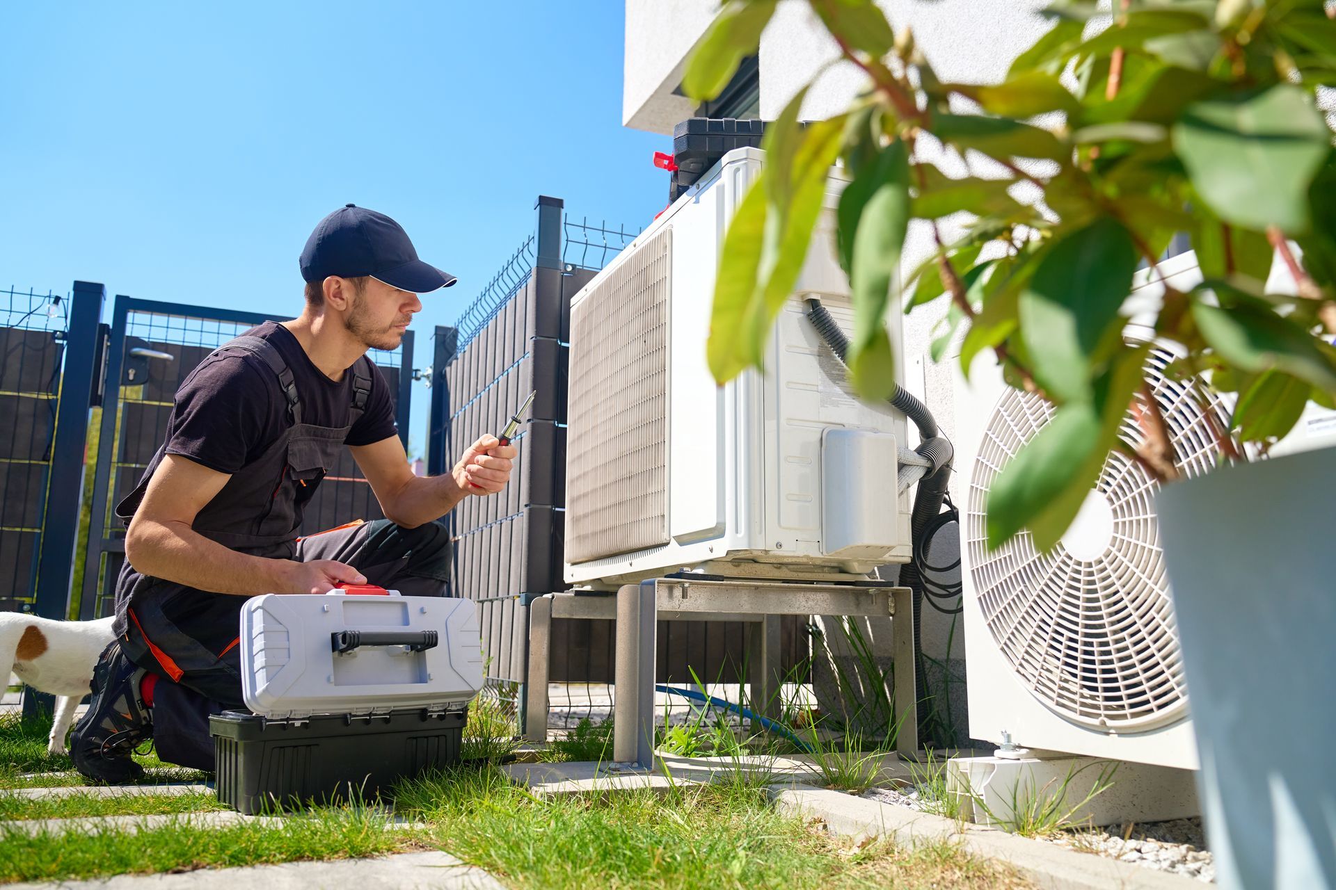 Emergency heating service technician repairing an outdoor heat pump unit Emergency heating service technician repairing an outdoor heat pump unit