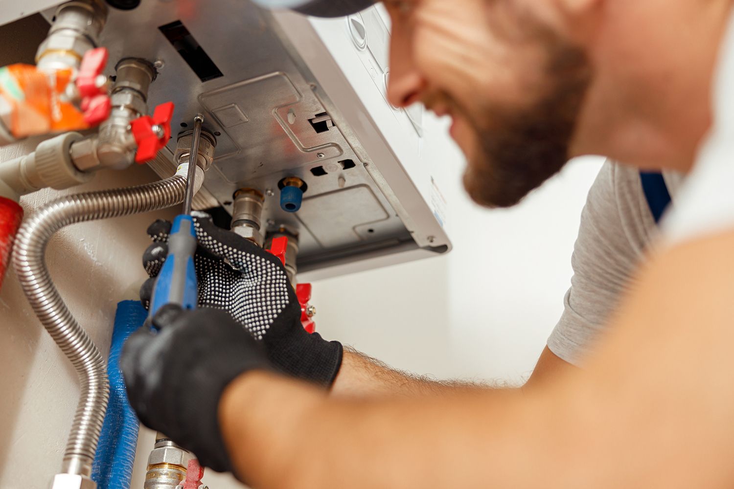 Plumber installing steel hot water system showcasing heating contractors, representing expert work. Plumber installing steel hot water system showcasing heating contractors, representing expert work.