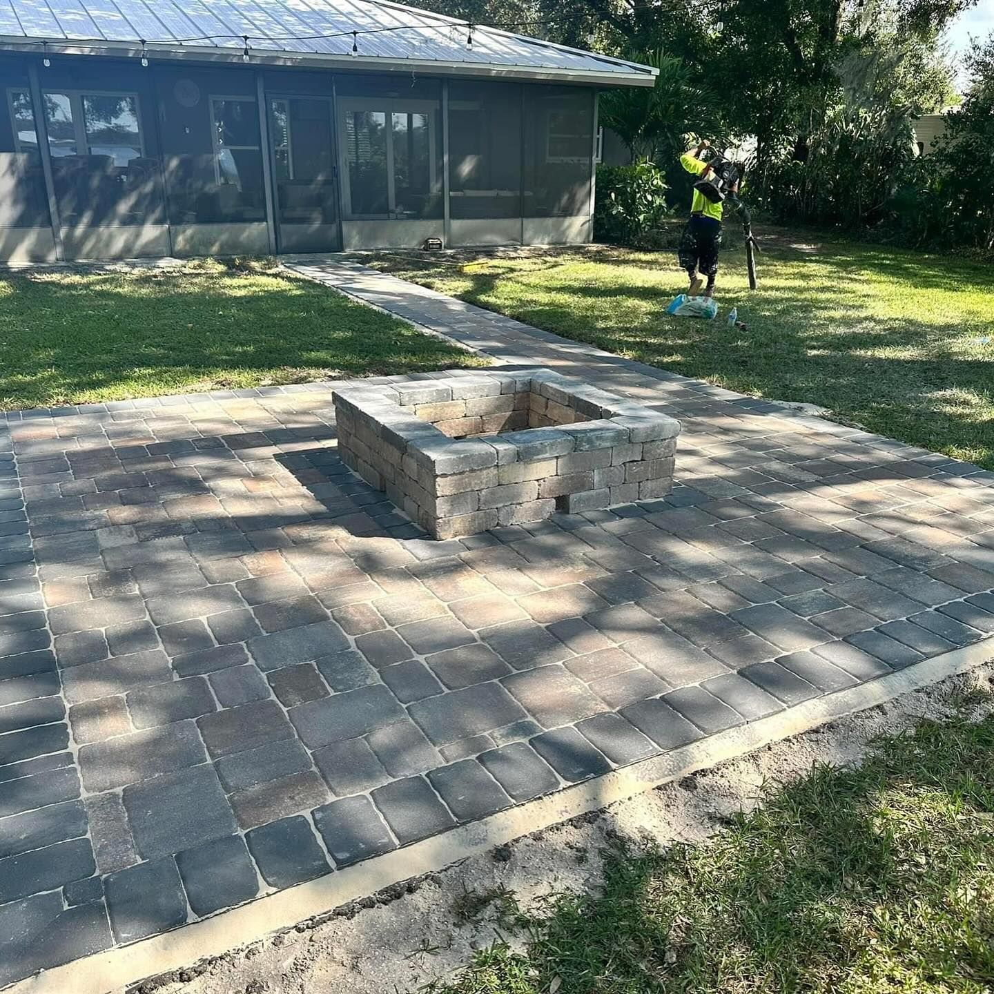 A fire pit is being built in the backyard of a house.