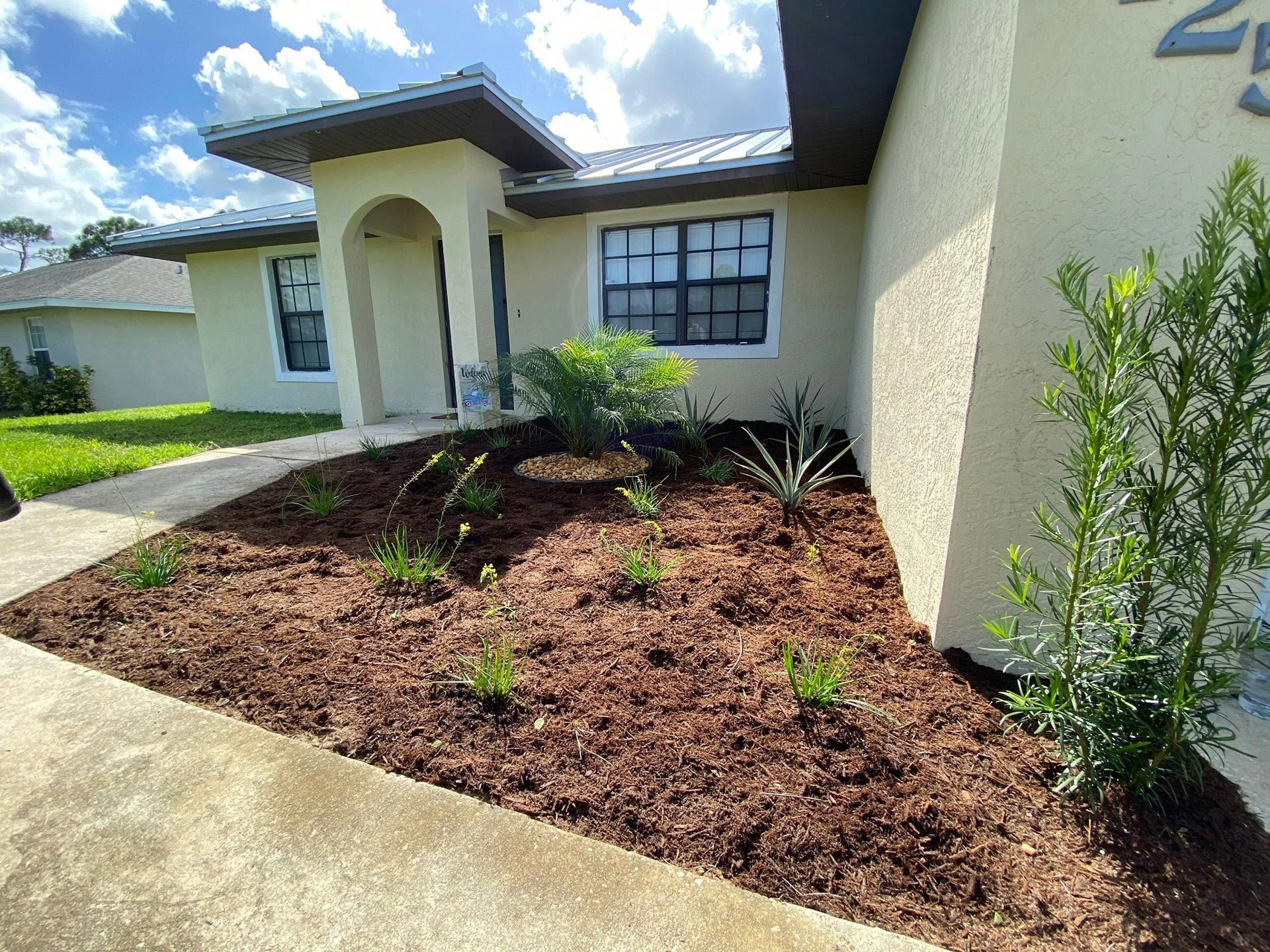 A white house with a lush green yard in front of it.
