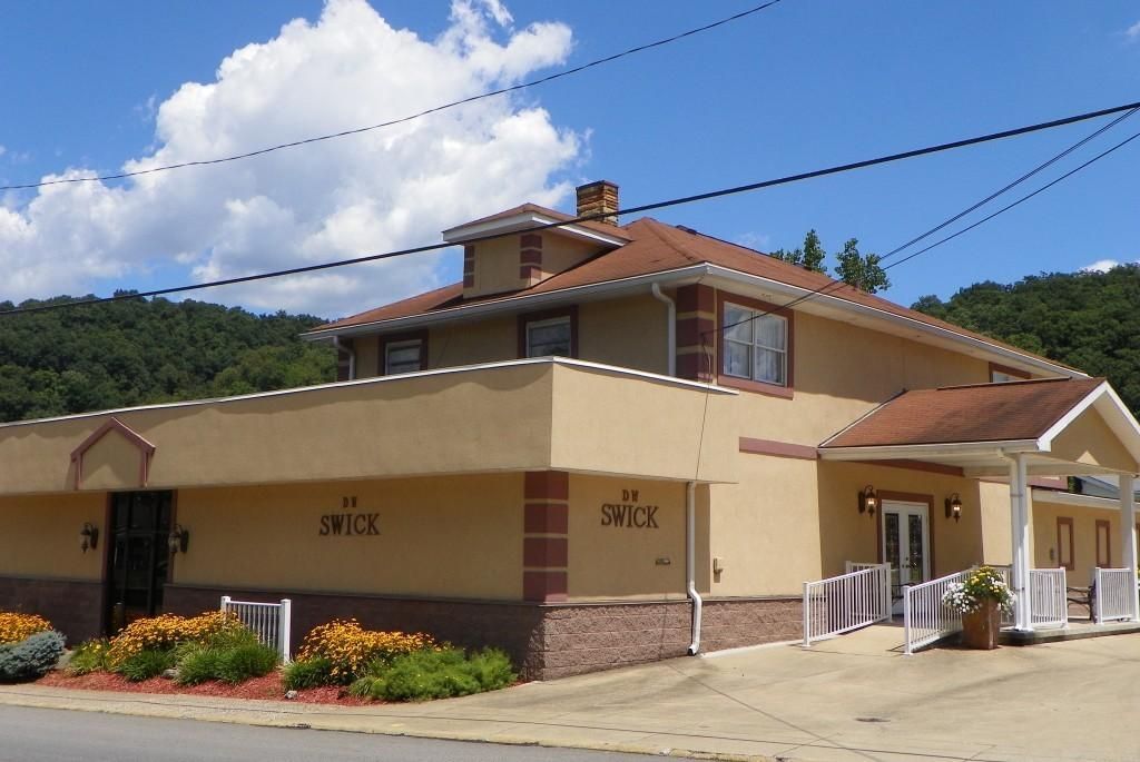 A large building with a red roof has the number 1103 on it
