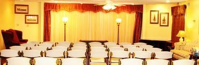 A large room with rows of white chairs in it